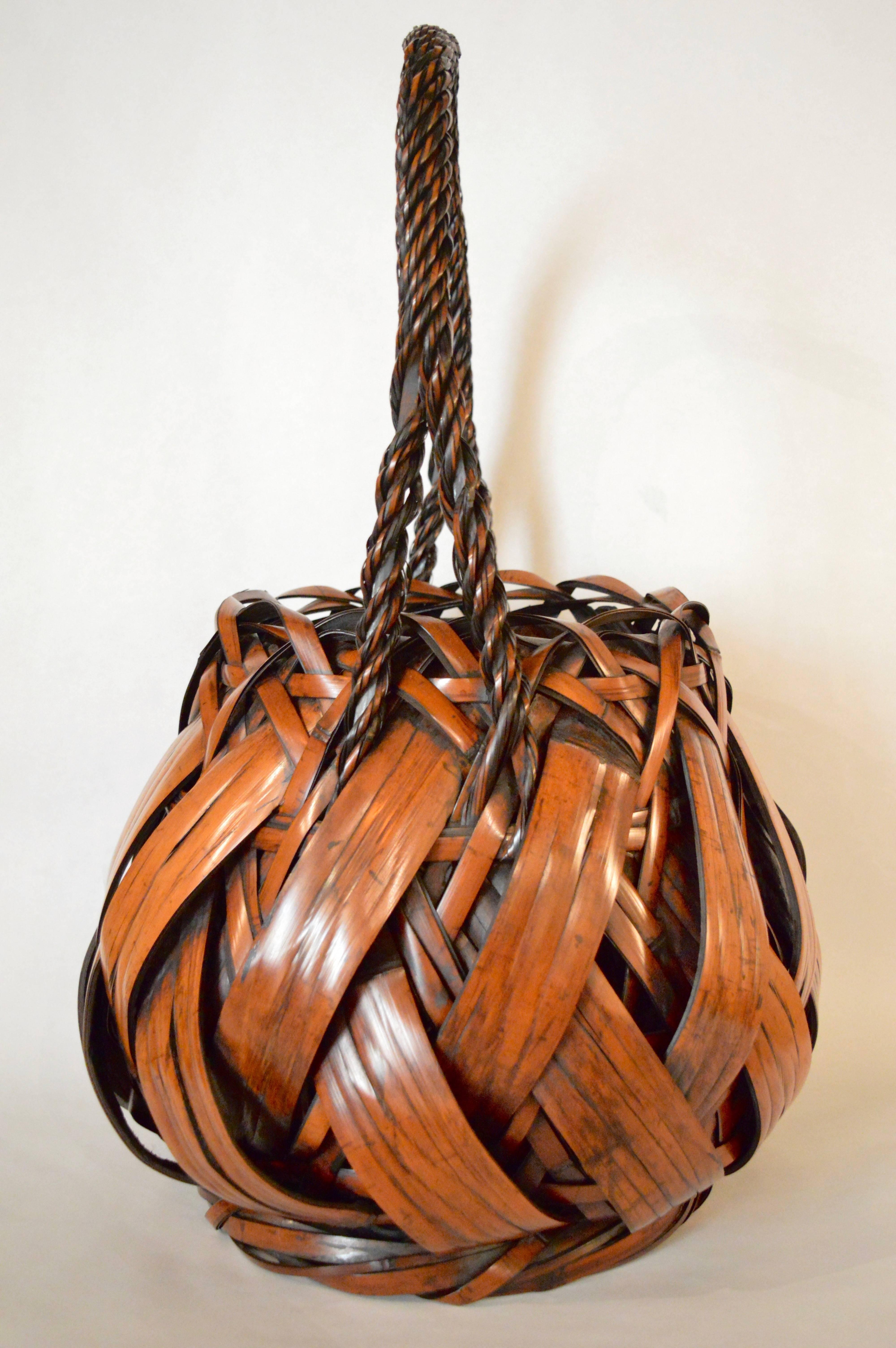 Antique Japanese ikebana basket made of woven bamboo with large strips of bamboo interwoven with a network of thinner strips and a tightly twisted handle Spectacular size.
Meiji period.