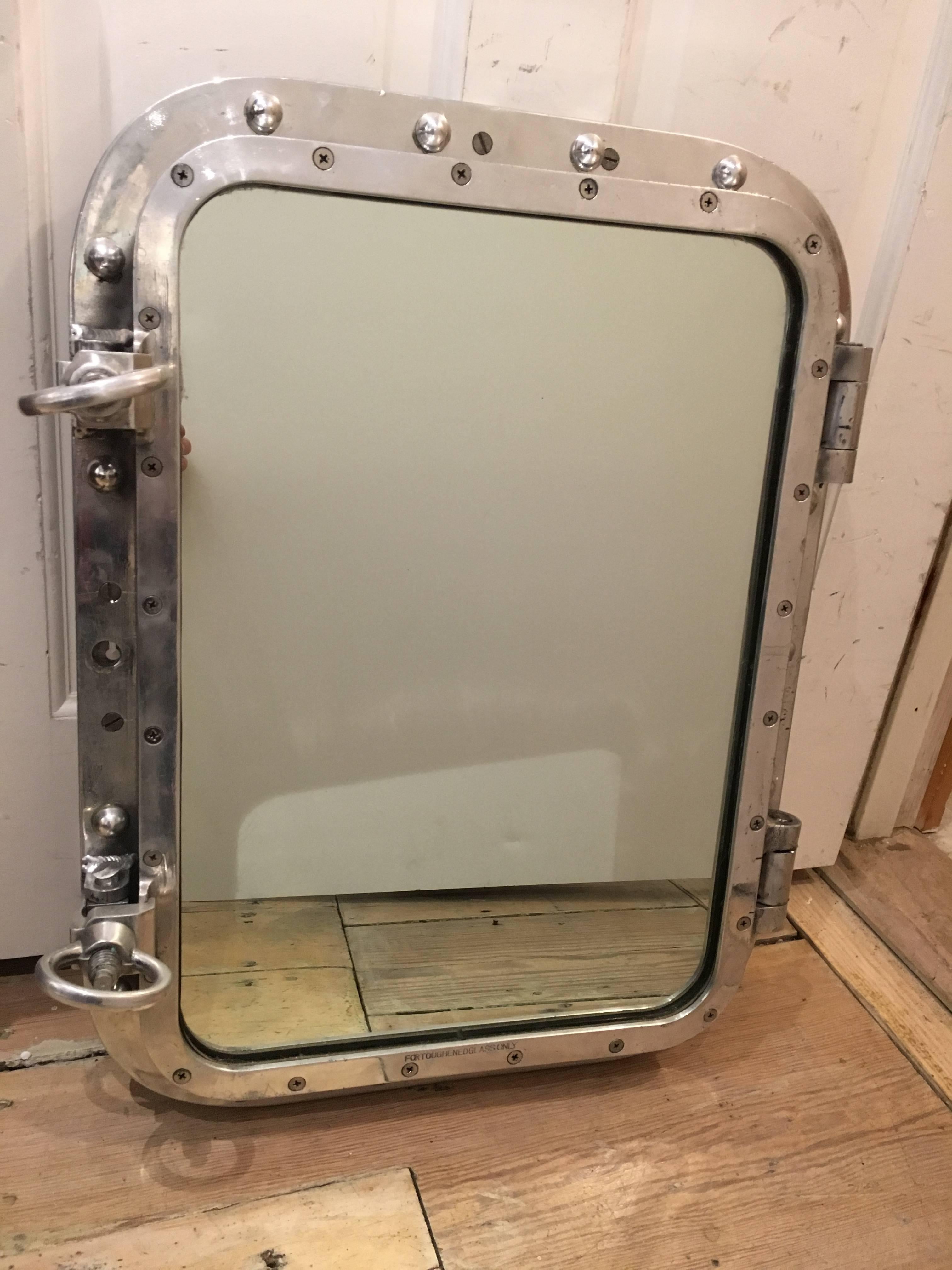 Original ship's porthole window converted to a mirror with operational 'keys' (as in the mirror or window will open).  Great to use over a recessed medicine cabinet or even as a dry bar tray.  Chrome, refinished.

