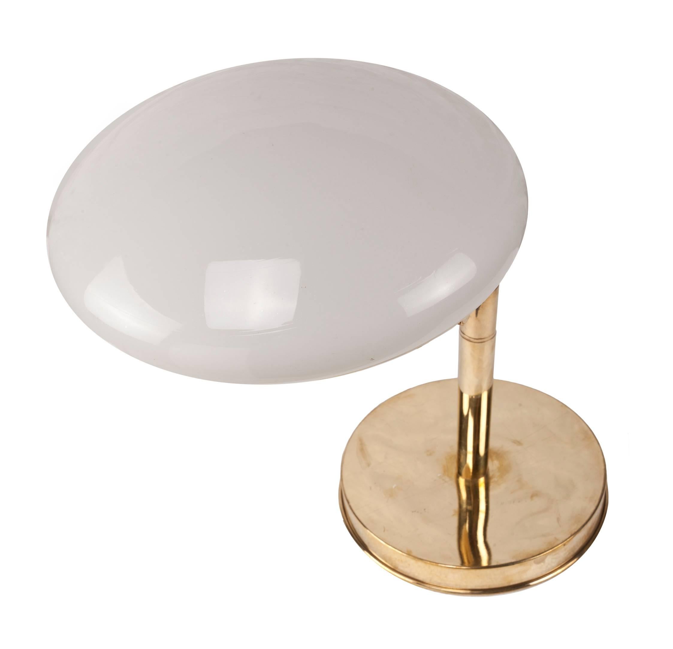 From a ship's stateroom, this pair of brass table lamps has an adjustable arm that swings out and lovely, domed milk glass shades. Measures: Base diameter is 8