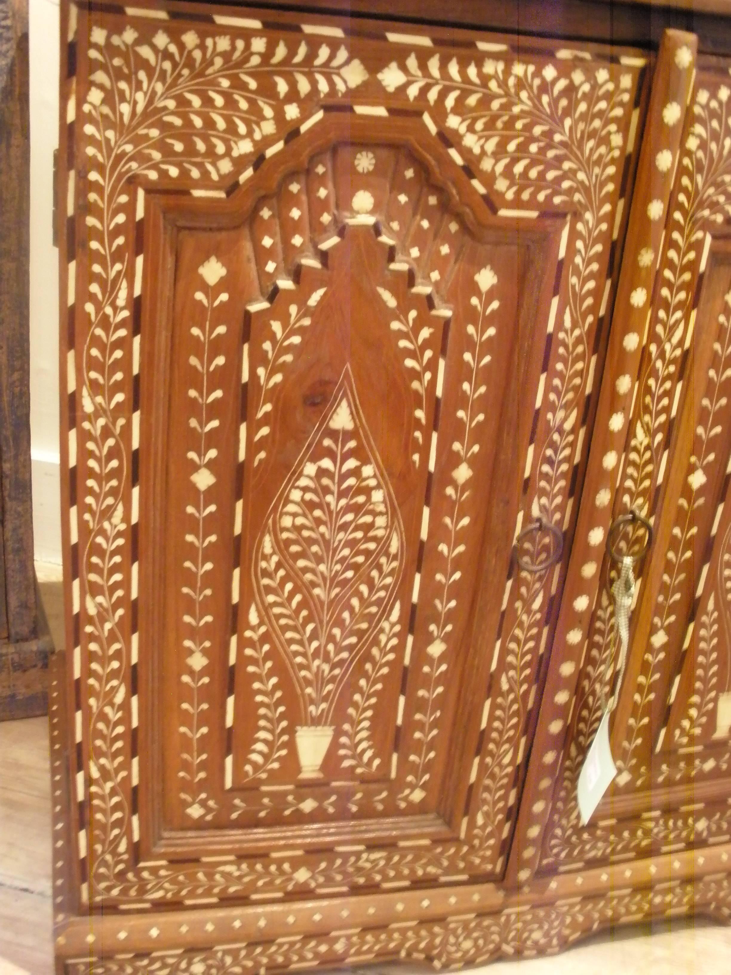 A fabulously intricate bone inlay teak cabinet with interior dividers and double door fronts. The workmanship on this piece is incredible given the small sizes and shapes of the of the inlay. It's always easier to inlay large, smooth-edged pieces,