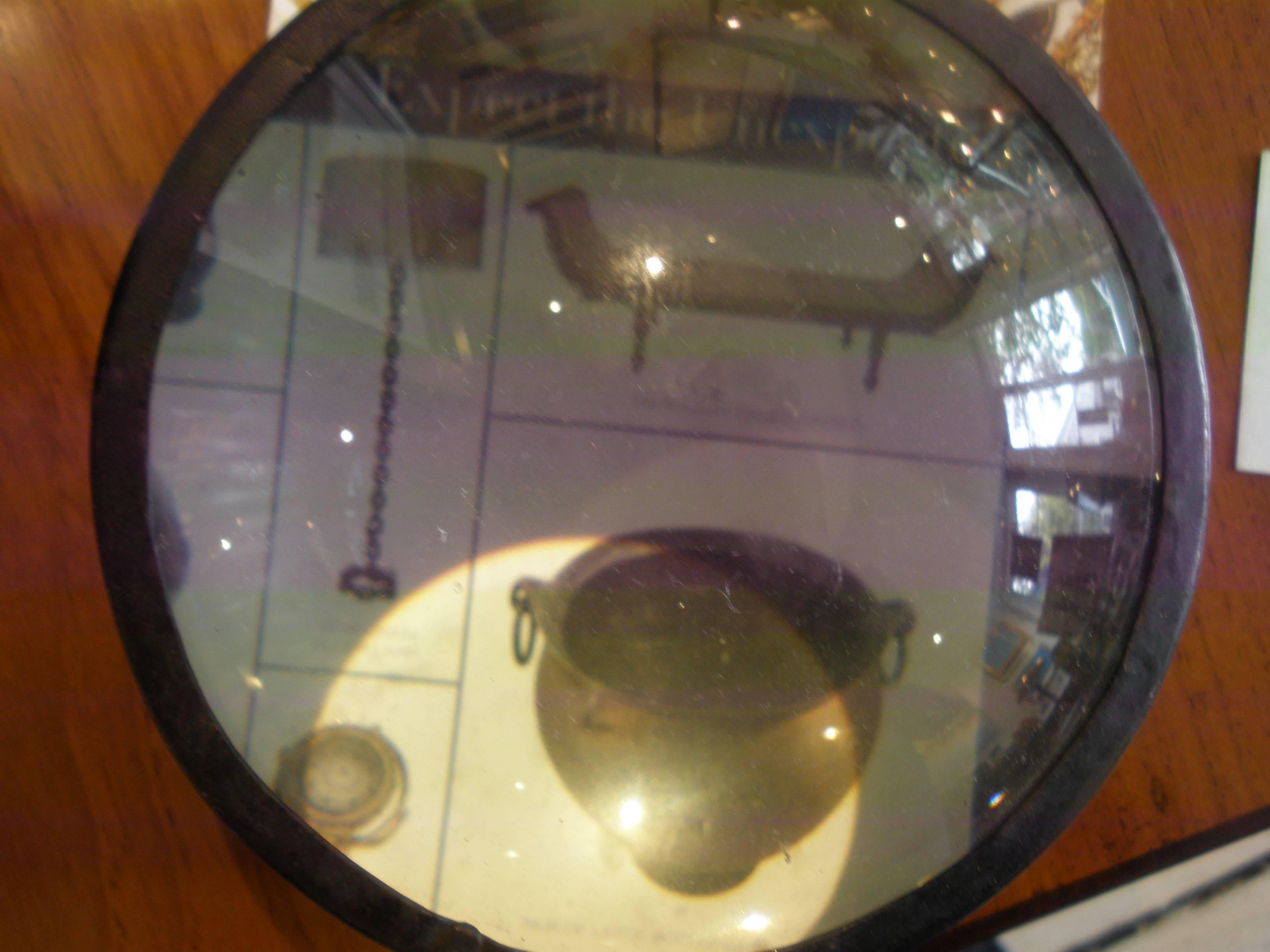 A ship's magnifying glass used to read navigational charts aboard ship. Made of iron with the ability to take the top cover off for cleaning purposes. Rare find.

Nautical Antiques located on Nantucket Island.