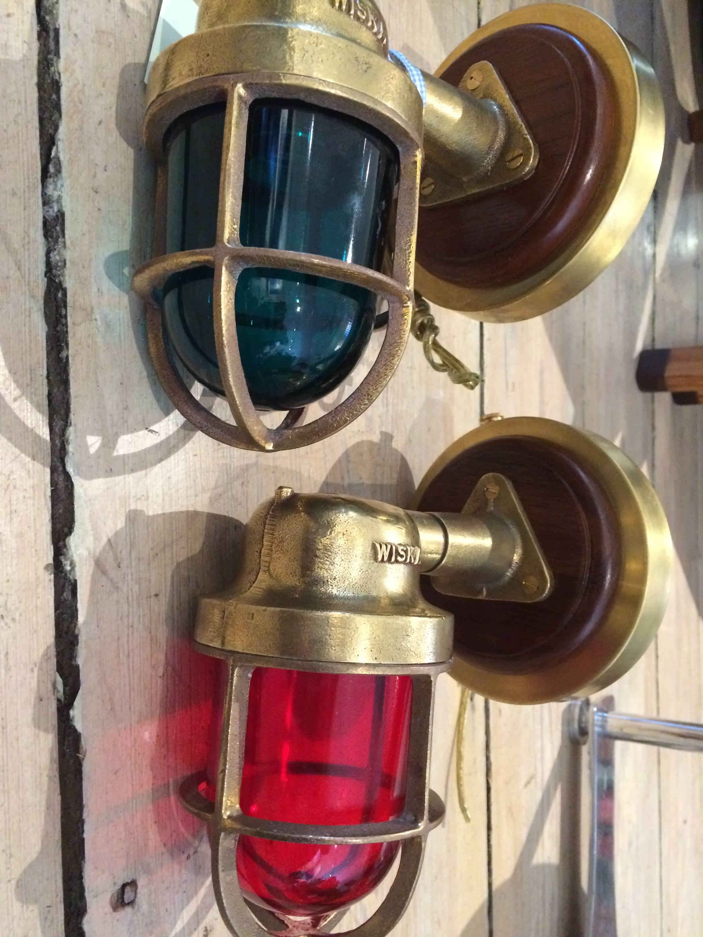 Pair of Mid-Century brass port and starboard navigational lights from a working ship. The teak and brass backs have been added for modern use. The wiring has been updated for American use and they take a regular size light bulb. Signed from the