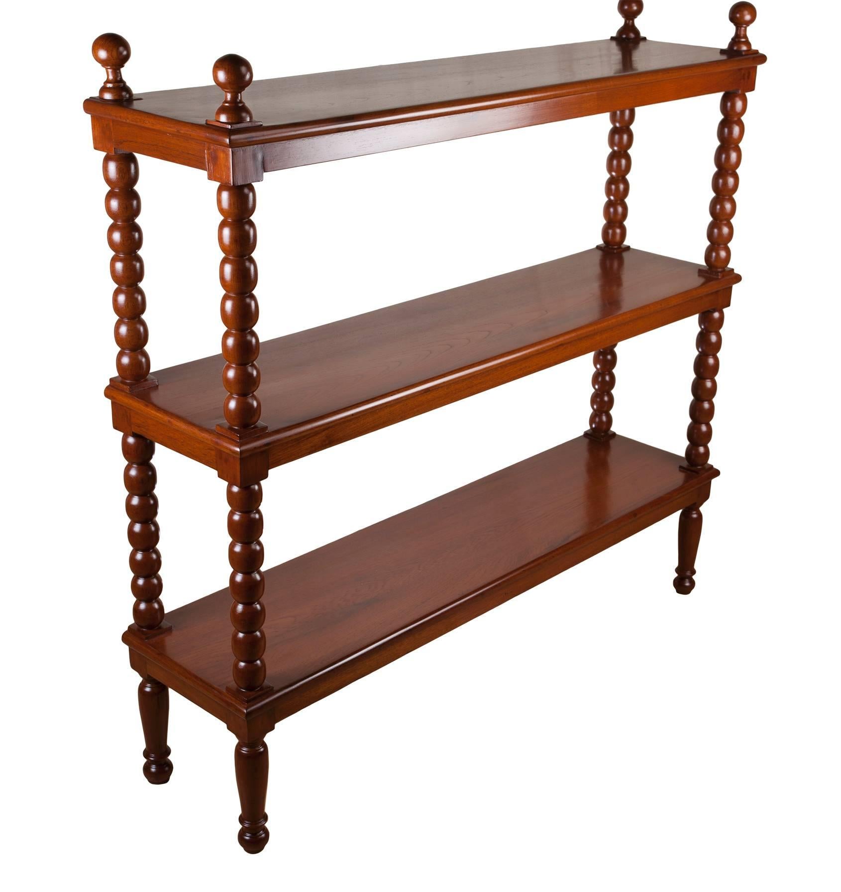 Handsome, Early 1900s mahogany étagère or bookcase with bobbin column supports with a tapered reeded leg with bead and ball foot; open shelving. Refinished. Distance between shelves is 15 inches. Colonial British. Height of 47