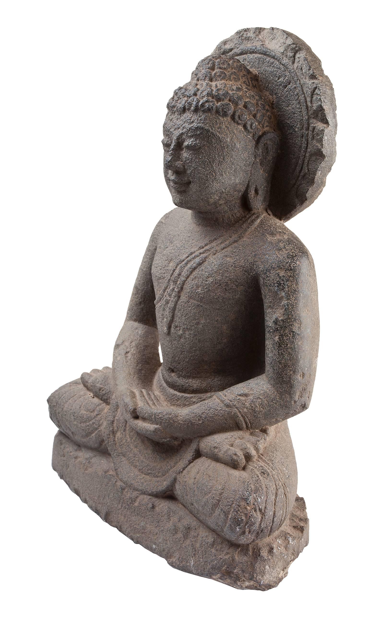 Full-form sitting Buddha with surrounding halo in a meditation posture or mudra. Specifically, the Dhyana mudra. Granite, 19th C, India.  The Dhyana mudra is the mudra of meditation, of concentration on the Good law, and of the attainment of