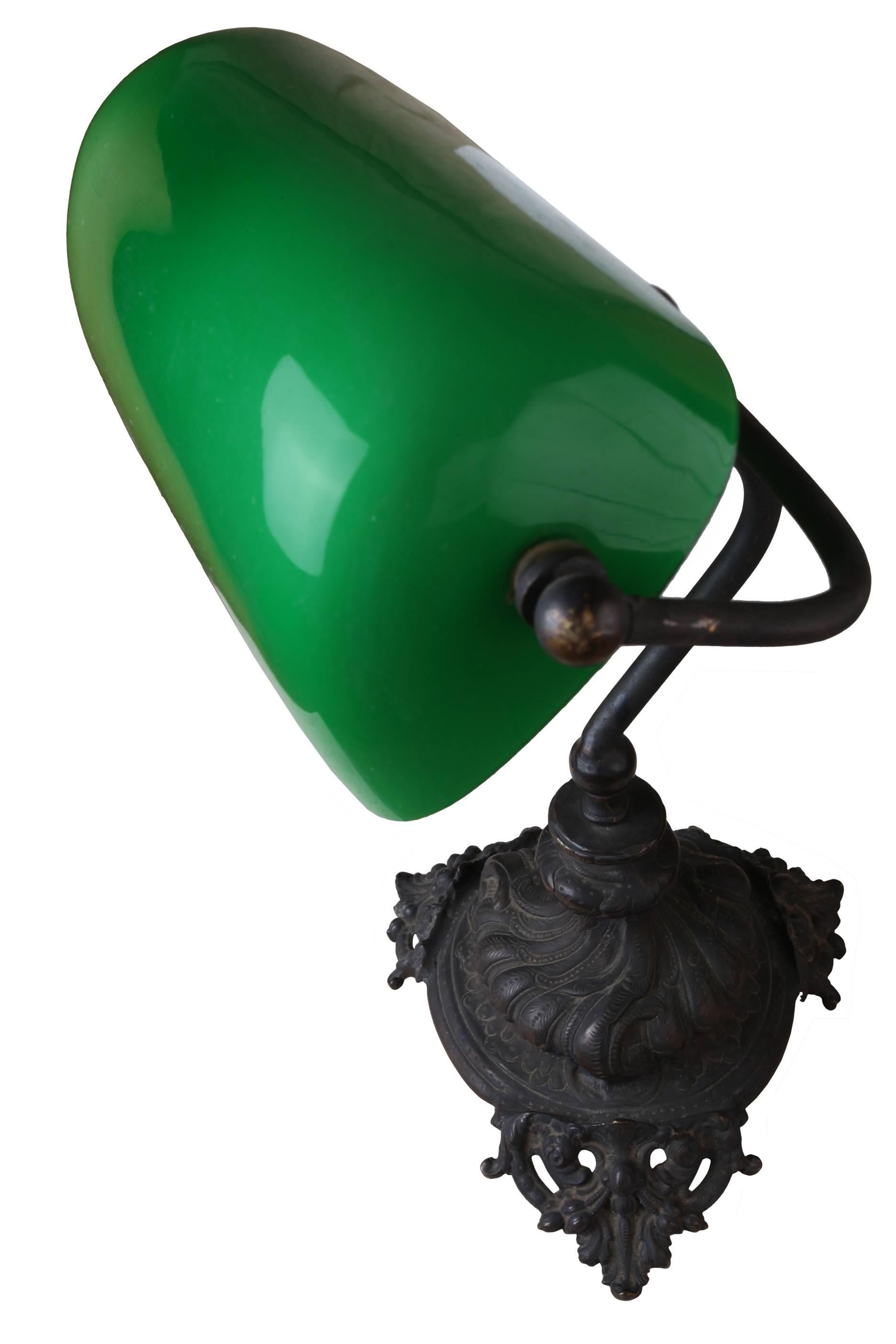 Emeralite green case glass shade on a lovely cast iron base with exquisite details on the base. Adjustable shade making it a perfect desk lamp. Shade measures 9