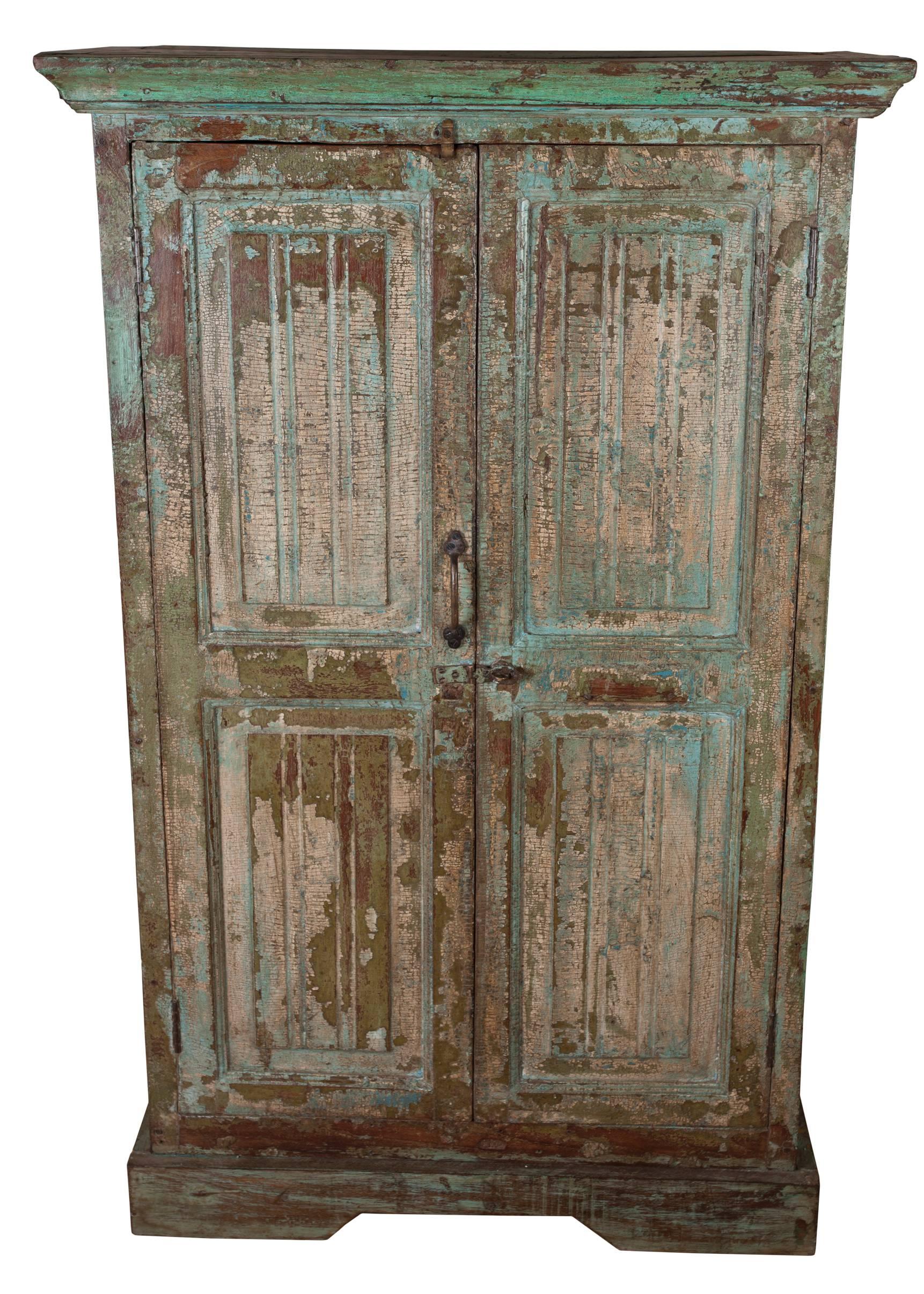 A teak cabinet with traces of its original paint. Distressed over time in a nice way. Double front doors and interior shelf, with a hasp closure. Raised panels on the door fronts, and attached top molding which adds 2