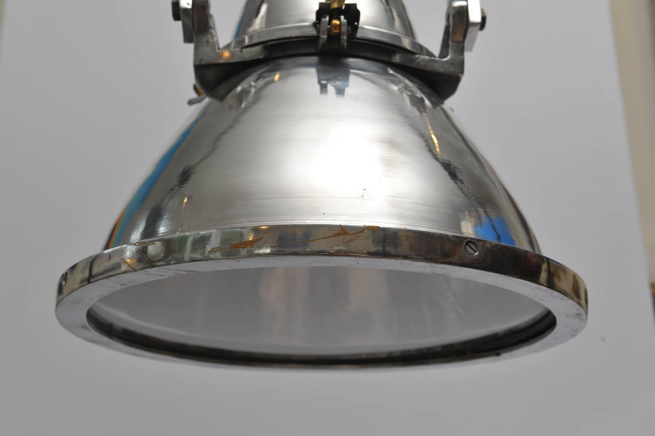 A chrome deck light from a working ship, with an iron bracket which is slightly offset but stays center when you hang it. Mid-century. Rewired for American use and takes one standard base light bulb. The light itself is 19 inches tall without the