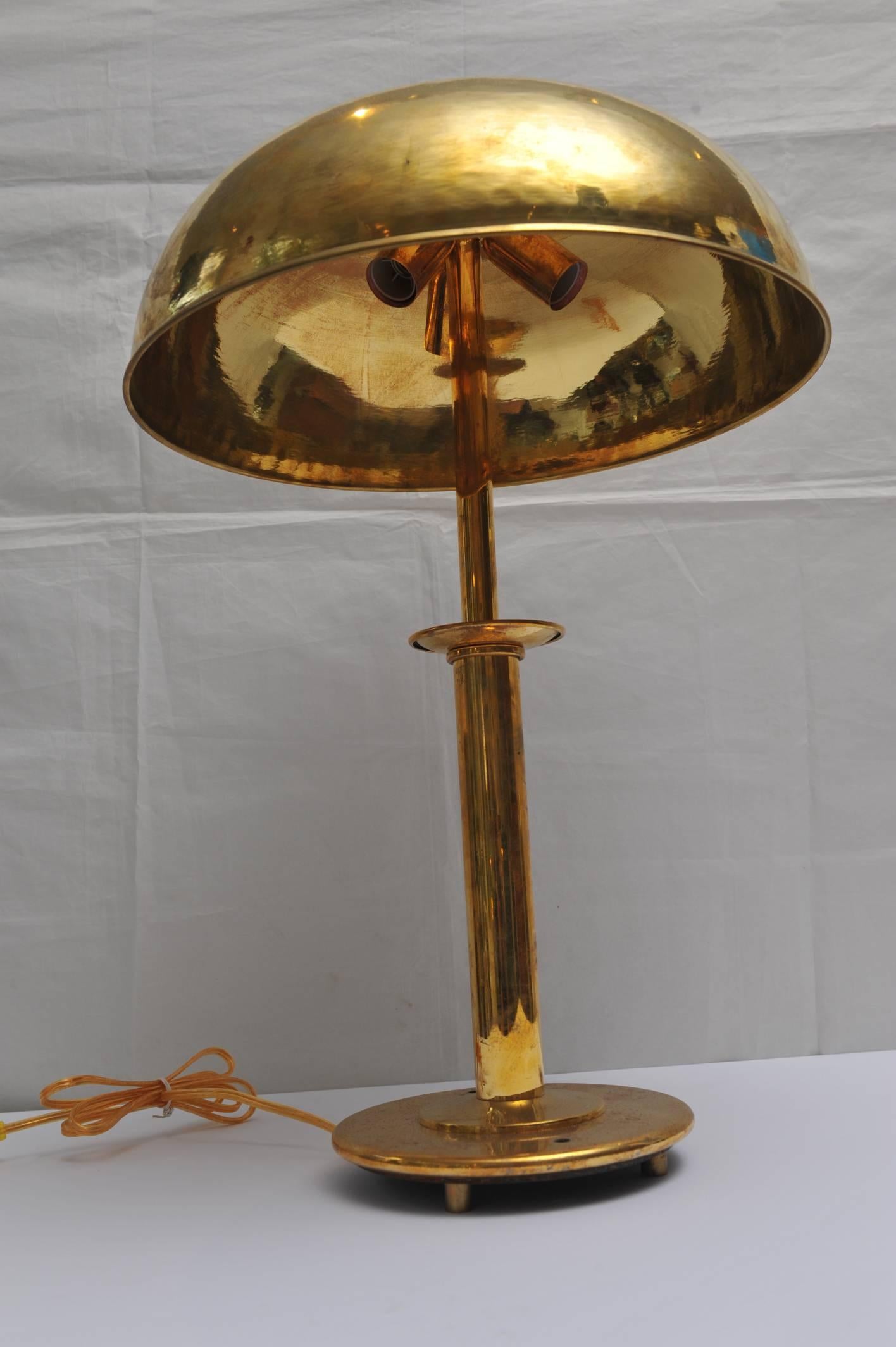 Pair of brass table lamps with brass dome shades from the stateroom of a Mid-Century ship. Takes three European (intermediate) bulbs which are easy to get. Rewired however, for American use. The base has a 7" diameter and just the shade is