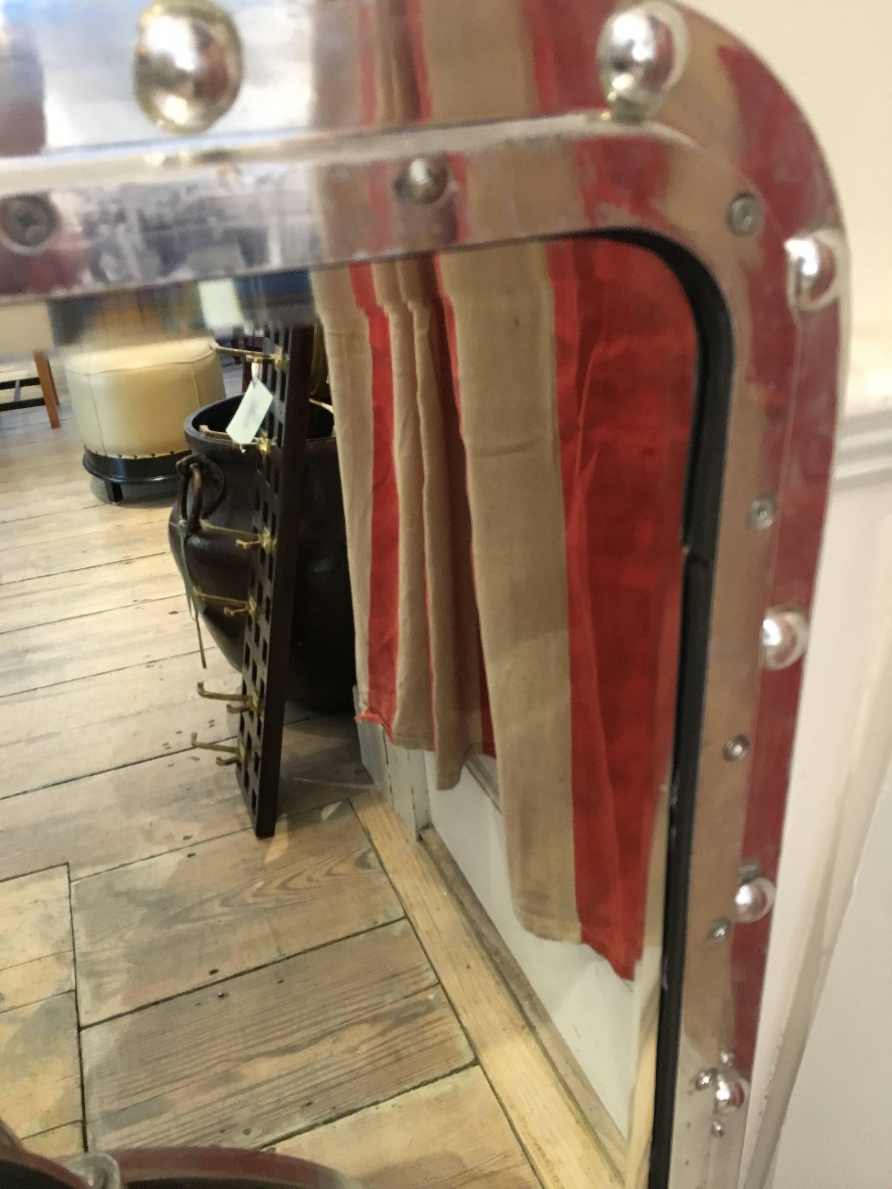 Original ship's chrome window with rivets and the glass changed out for a mirror with bevelled edges. I had four brackets centred on each side of the back to aid in hanging either horizontally or vertically.

Nautical antiques located on Nantucket