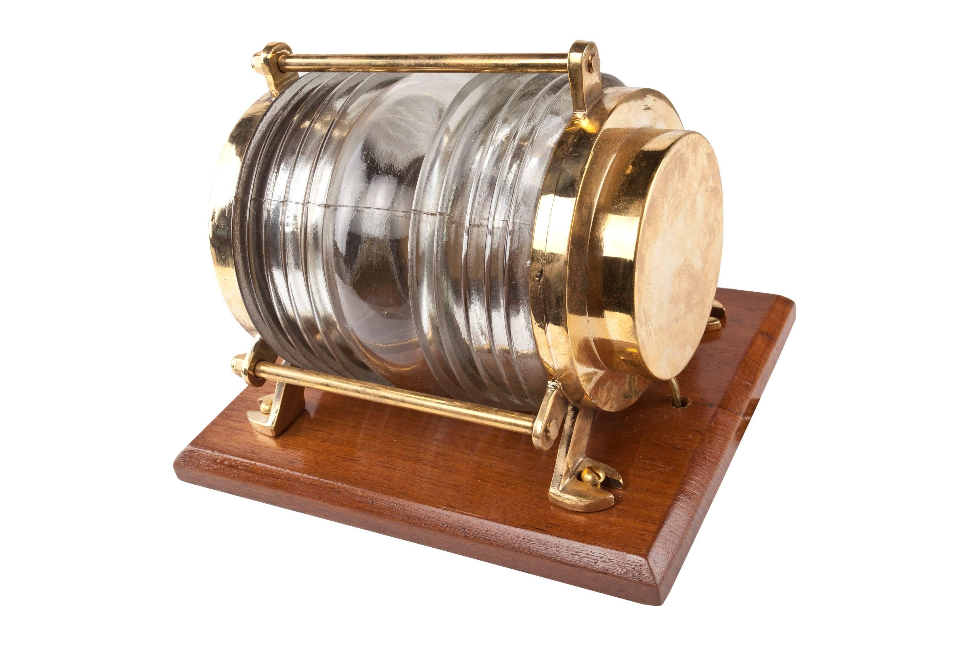 Pair of original ship's brass post lights with Fresnel lens glass mounted on a beveled teak backplate for easier installation. The top round brass plate unscrews for access to the bulb, which is a regular size base and these have been rewired for