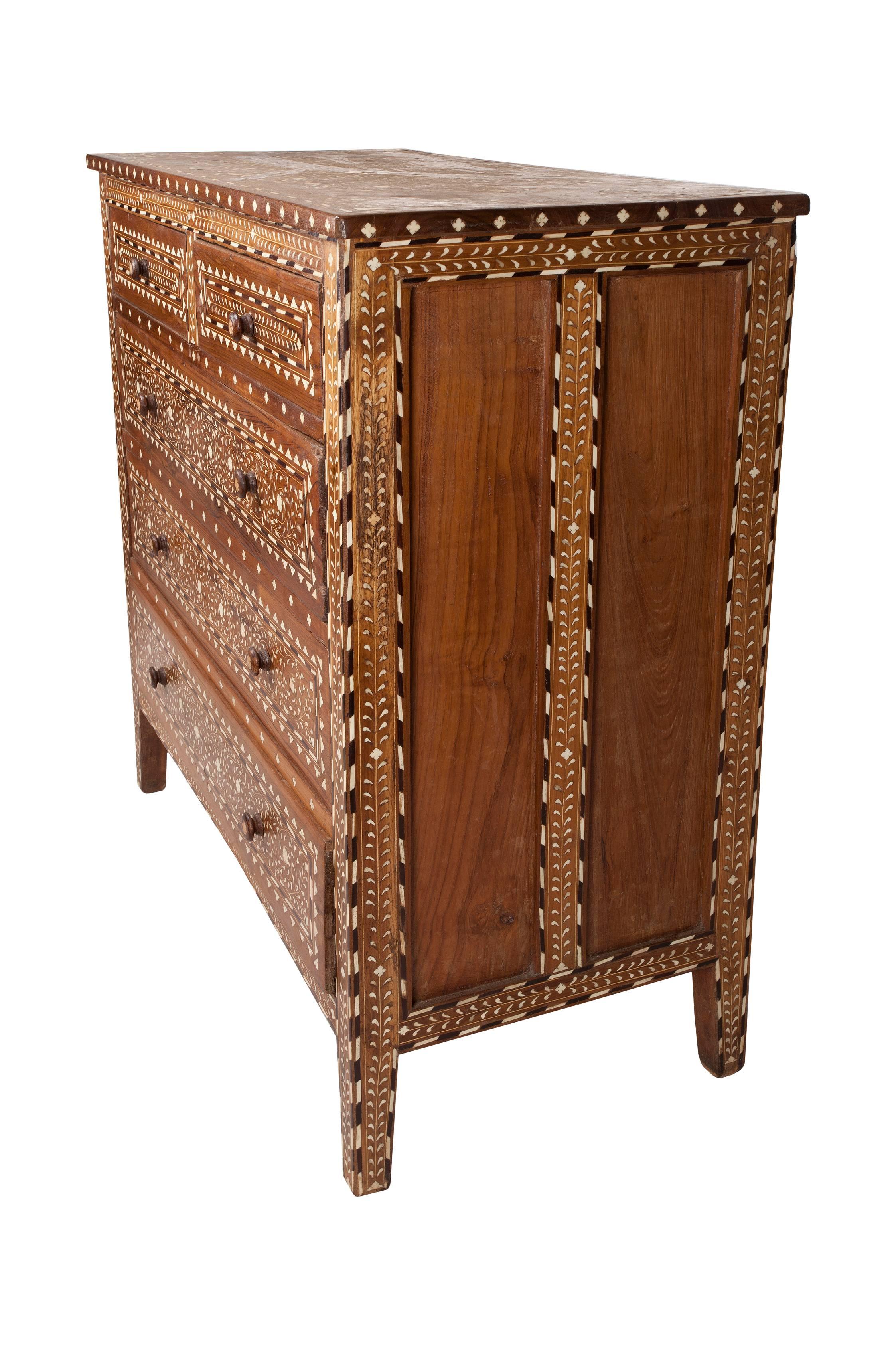 Early 1900s, teak chest of drawers with exceptional and intricate bone and rosewood inlay, India. Two over three drawer configuration with wood and inlay drawer pulls. The small size and detail of the inlay work is incredible.