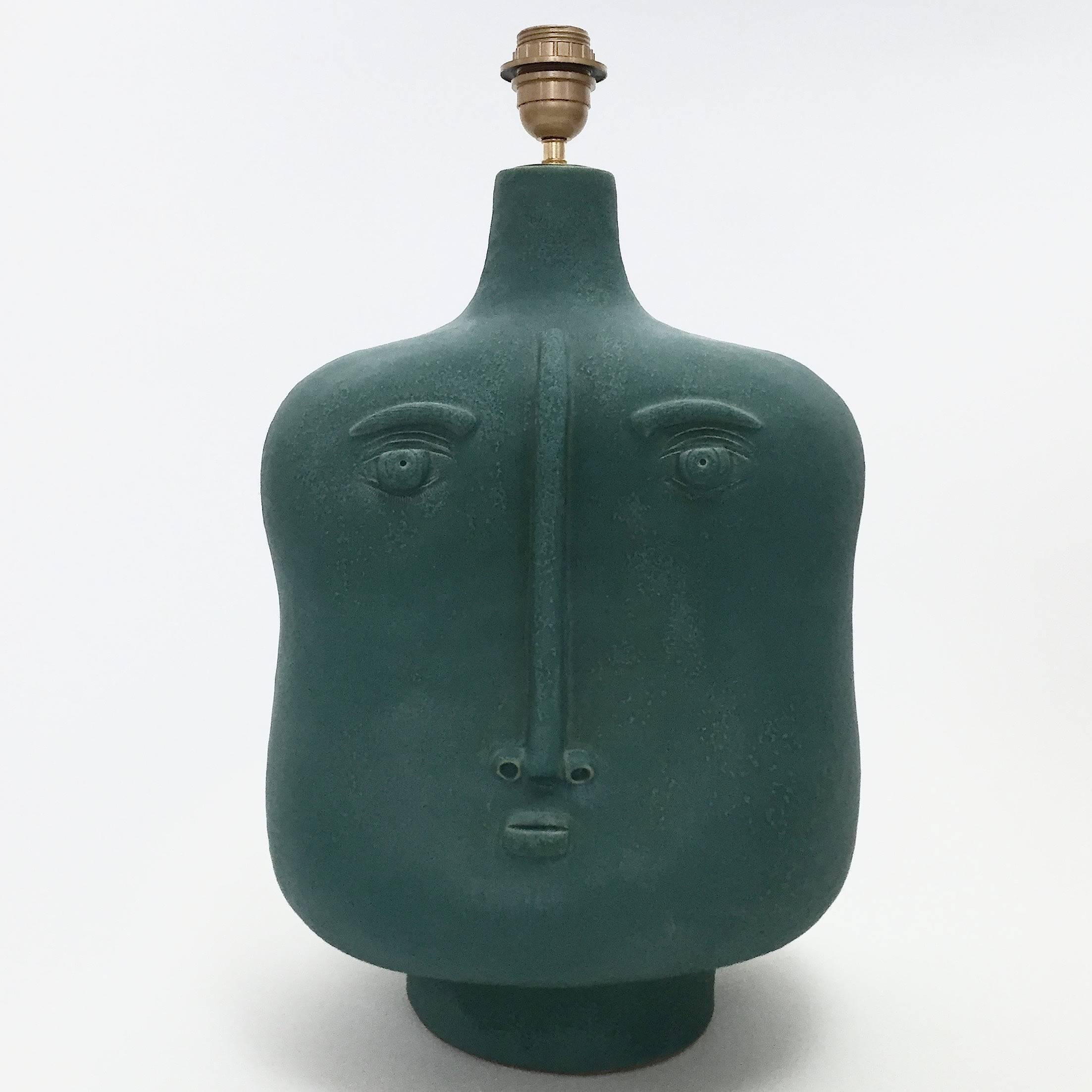 Important biomorphic shaped lamp-base, stoneware glazed in tons of cloudy teal blue/green and decorated with stylized double faces front and back.

One of a kind hand-sculpted piece, signed by the French ceramicists: Daniel Derock and Loïc de