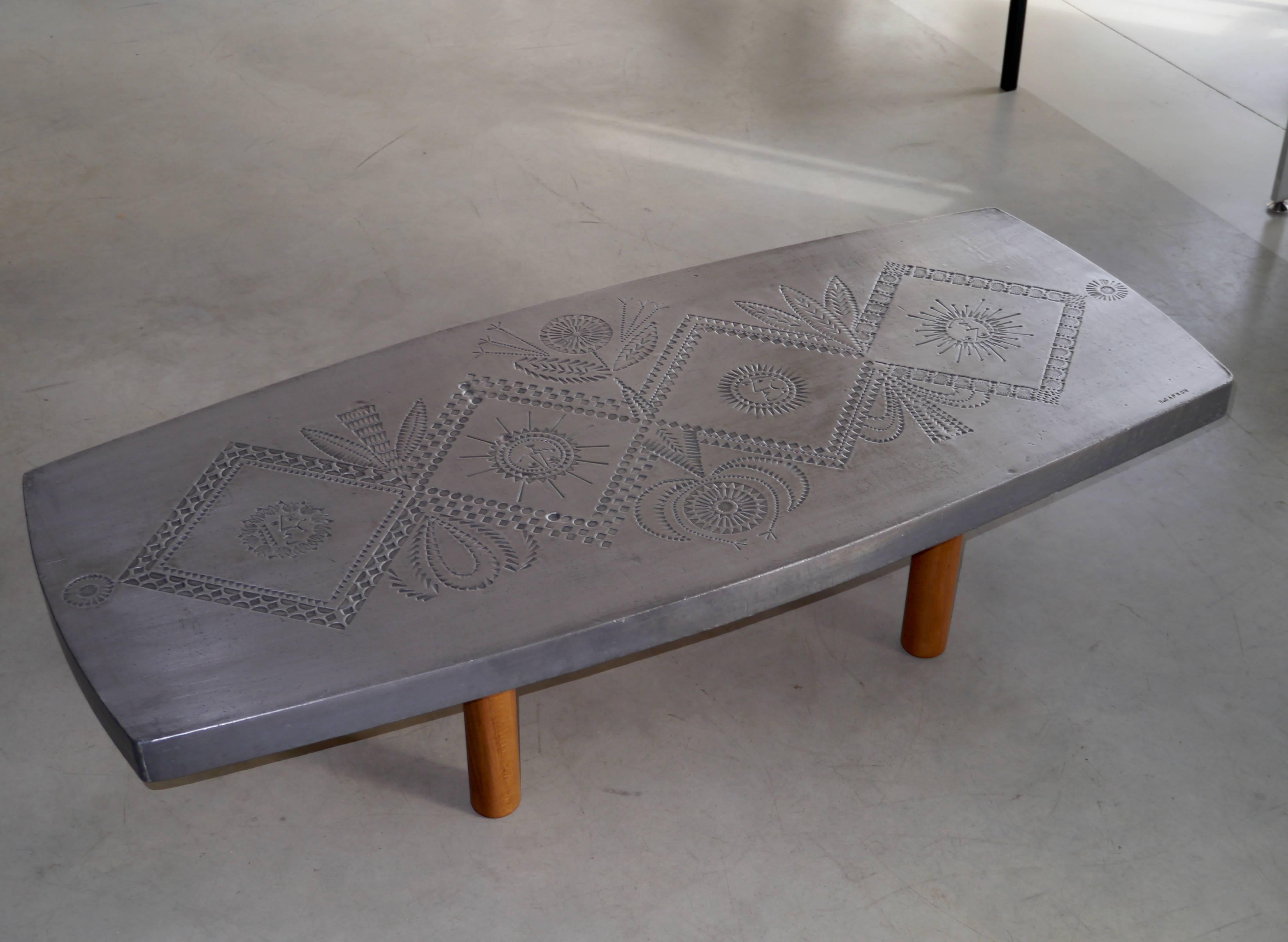 Exceptional coffee table with hand-worked stamped lead top.

An amazing work realized in the early 1970s with Jean Derval.
Stamped Roger Capron.

Irregularities and slight surface scratches must be considered as part of this work executed on