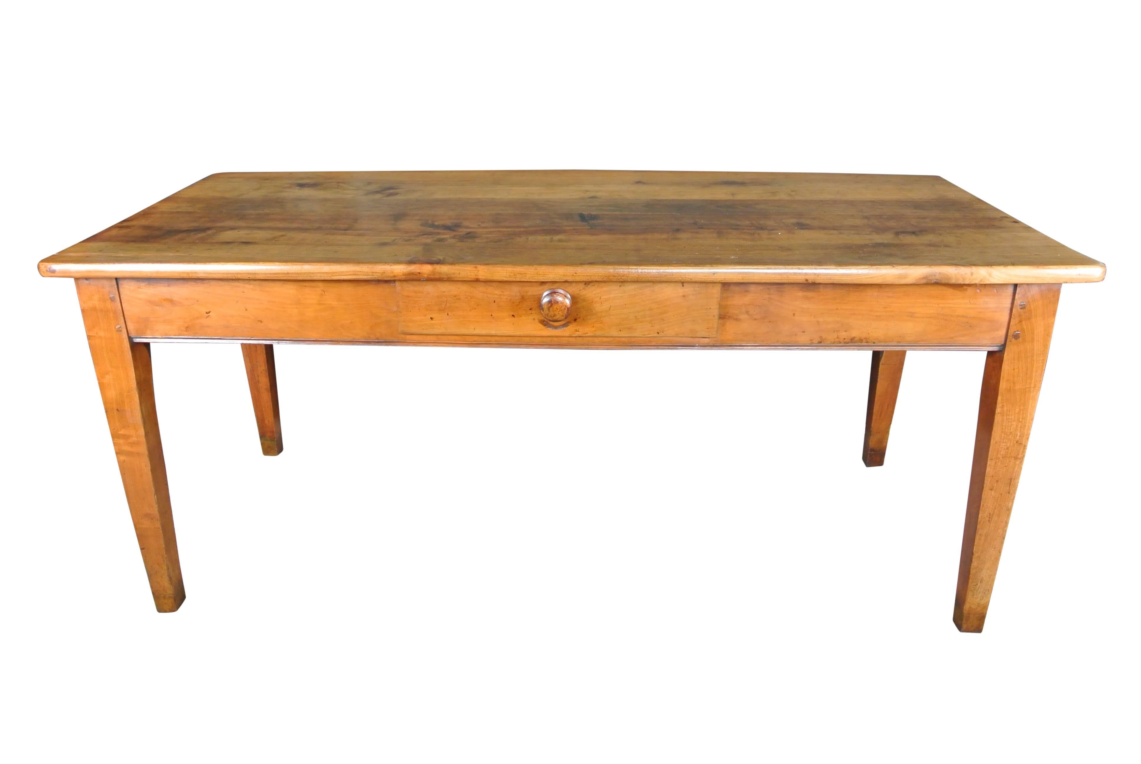 A large beautifully figured French cherrywood farmhouse kitchen table with a central drawer. Extraordinarily good color.