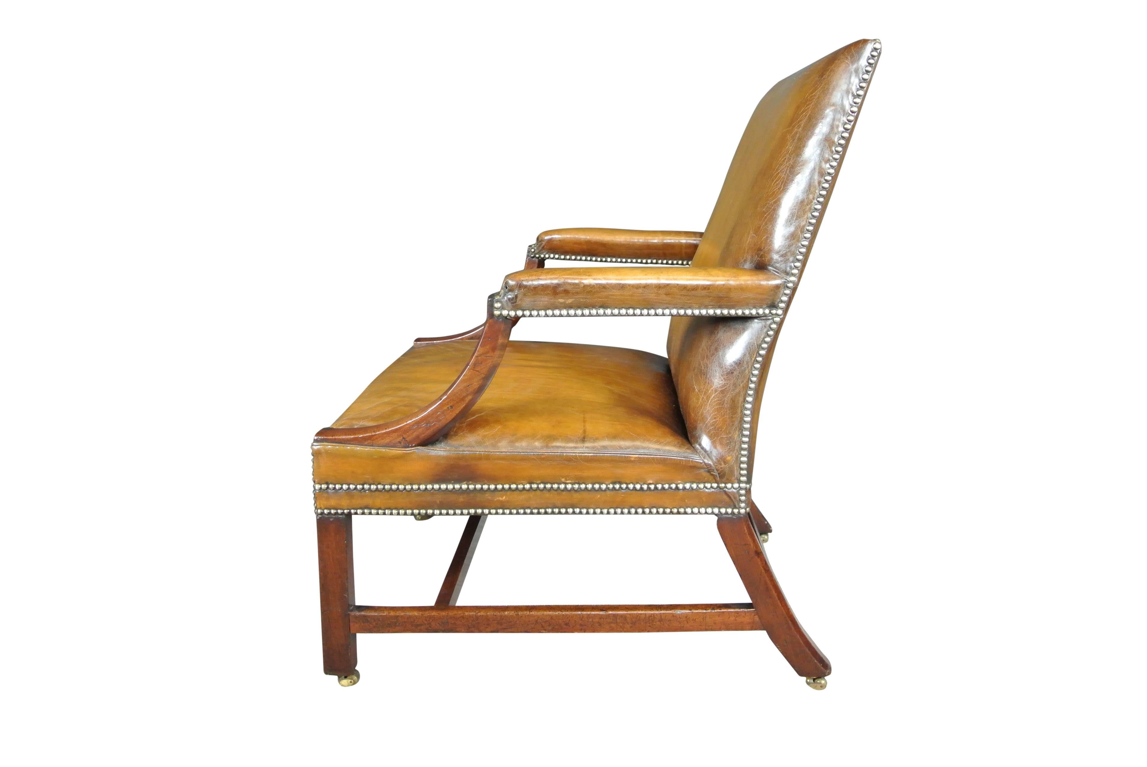 George III mahogany Gainsborough chair of large proportions raised on chamfered legs, recently reupholstered in a close buttoned antiqued hide Provenance Hinton house excellent condition.