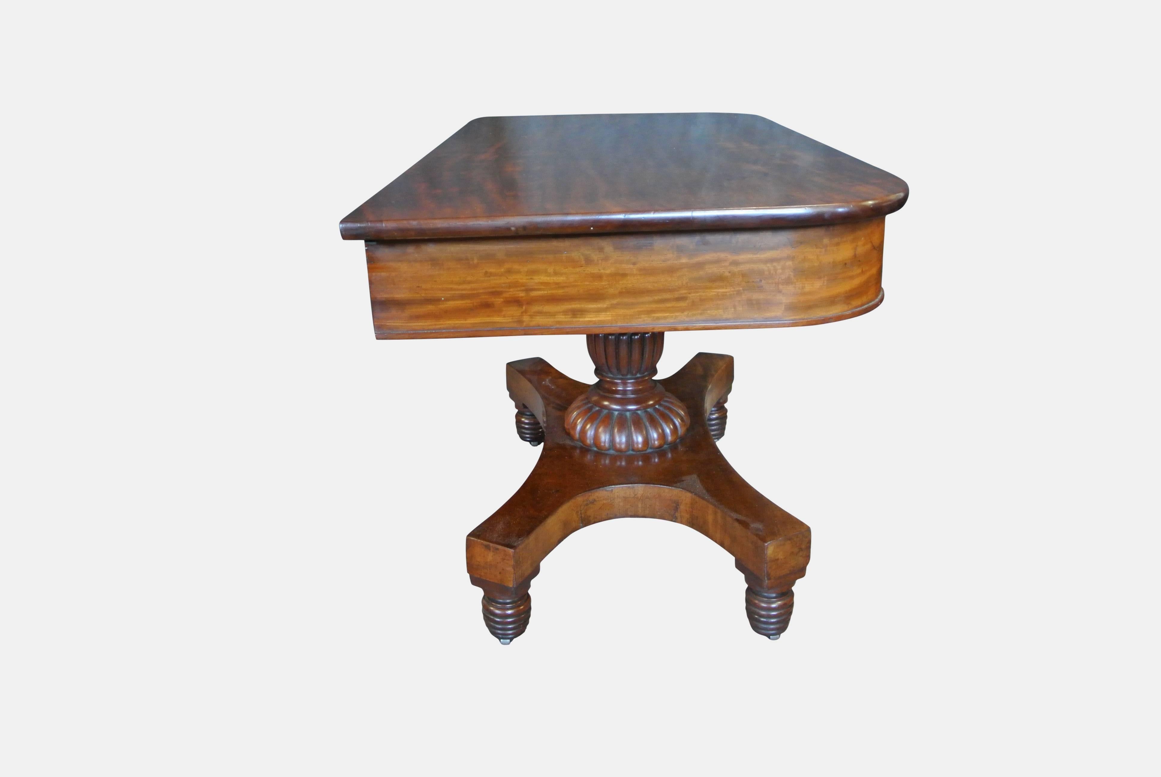 Pair of Regency mahogany table ends with turned gadrooned stems on quadripartite bases with beehive feet on brass casters. More recently been used as console tables.