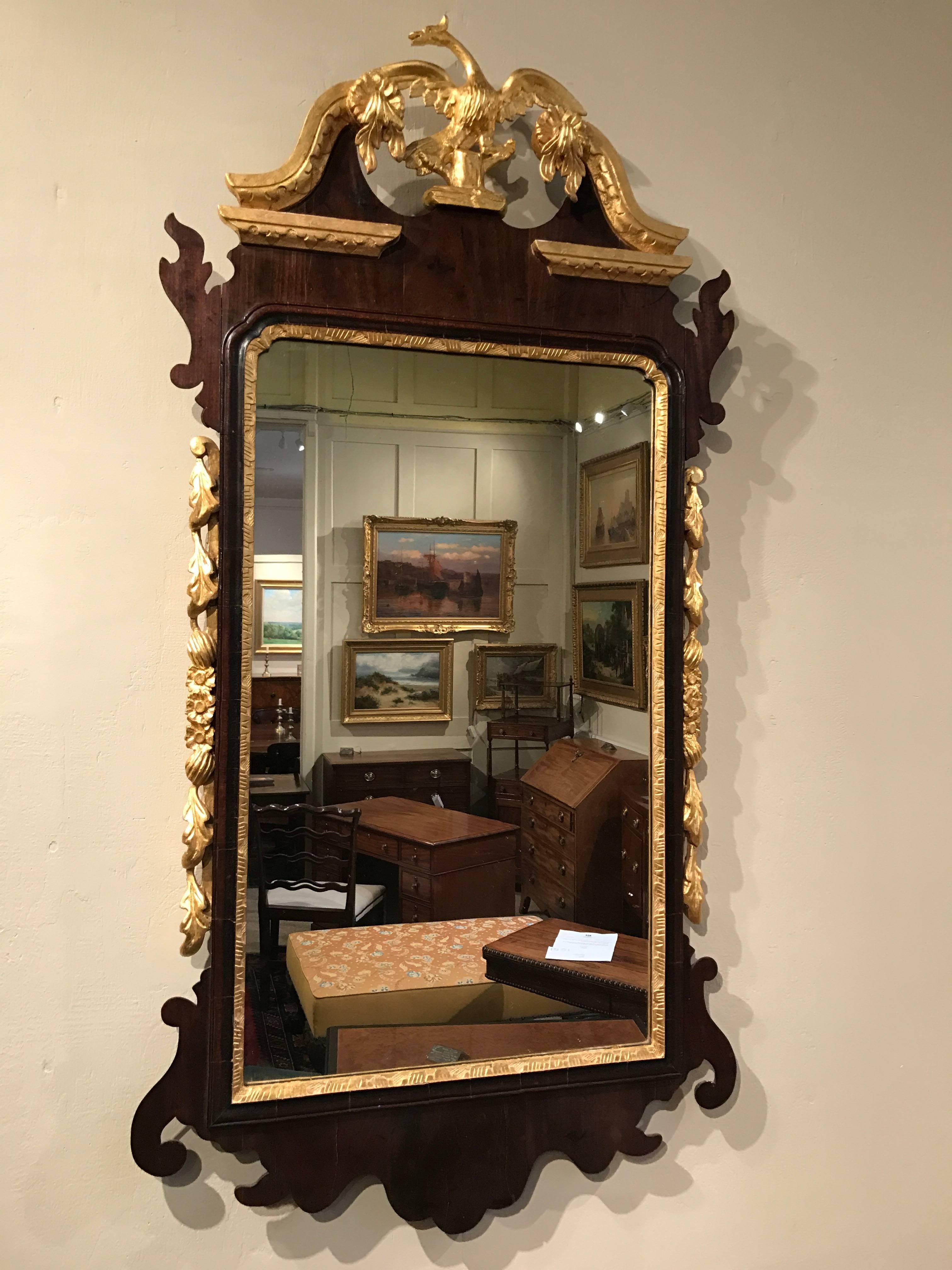 An elegant early Georgian style mahogany and gilt wall mirror with a ho-ho bird crest.