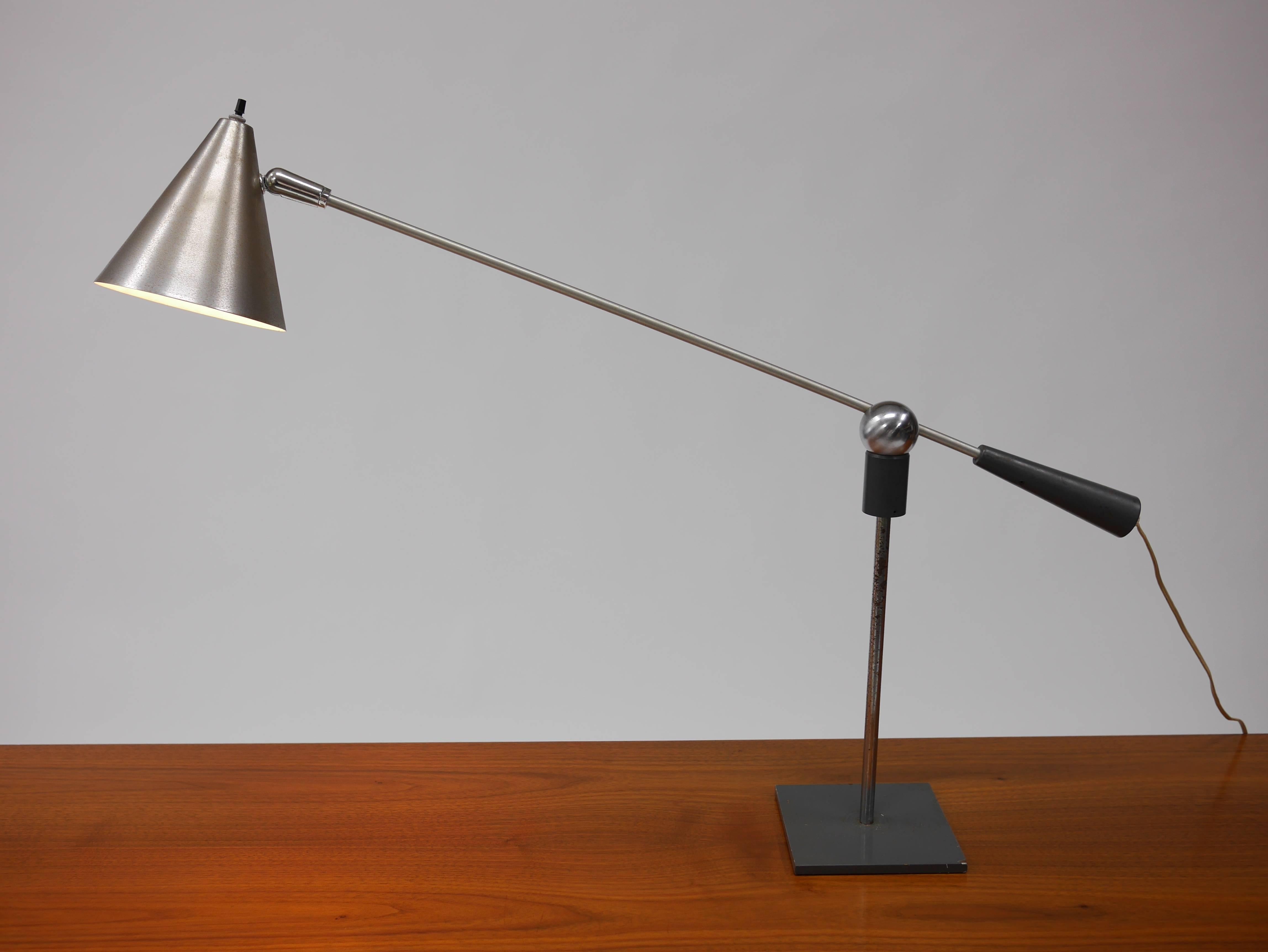 MoMA lamp by Gilbert Watrous for Heifetz. Nice, large, early example. Original patina.

The Watrous' lamp won a “Good Design” award for an intriguing low-cost light fixture featuring a pivot comprised of a magnetized steel ball residing