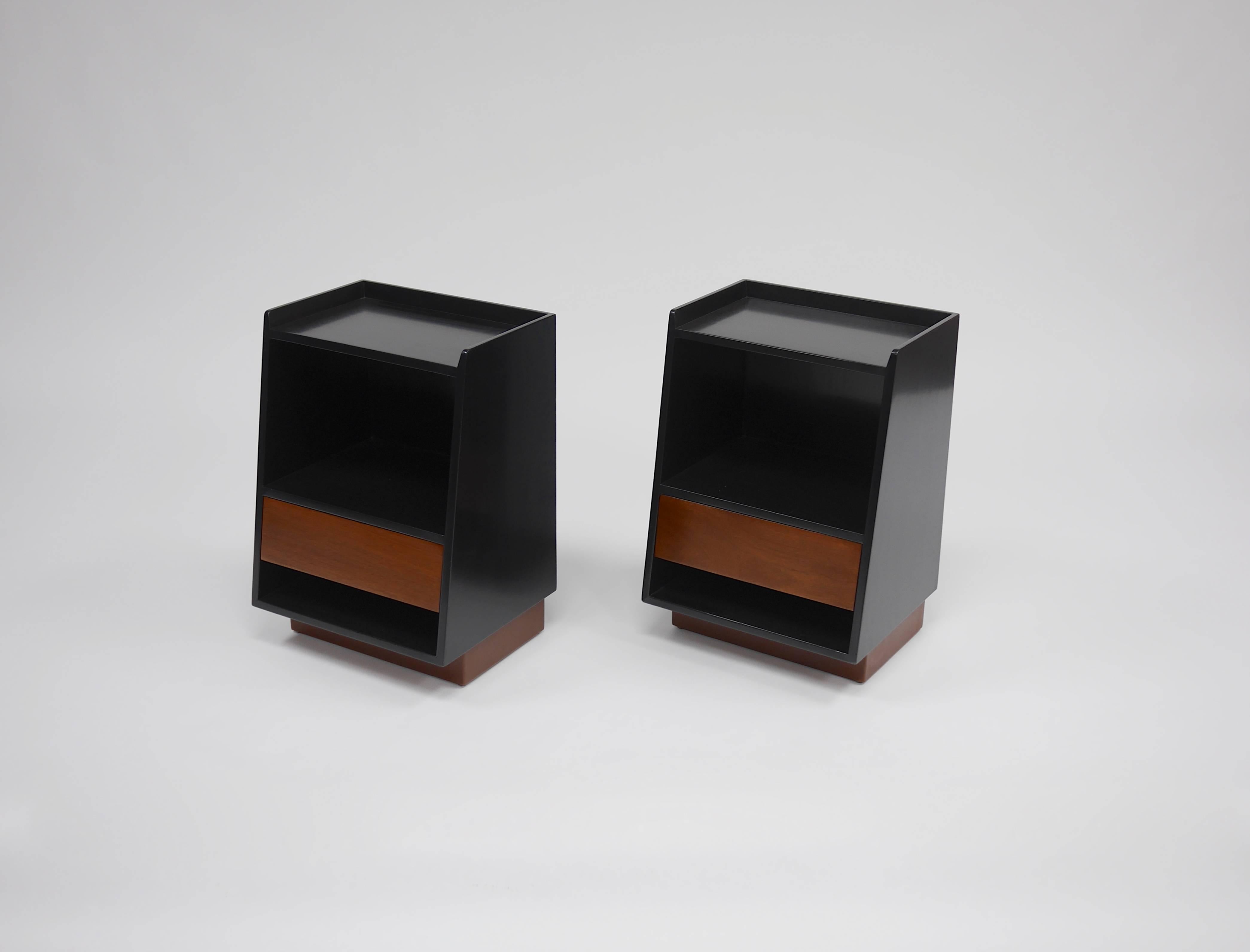 Pair of nightstands by Edward Wormley for Dunbar. Wedge shaped, two tone lacquer, dark walnut cases and lighter drawer fronts, leather plinth bases. Measures: 17
