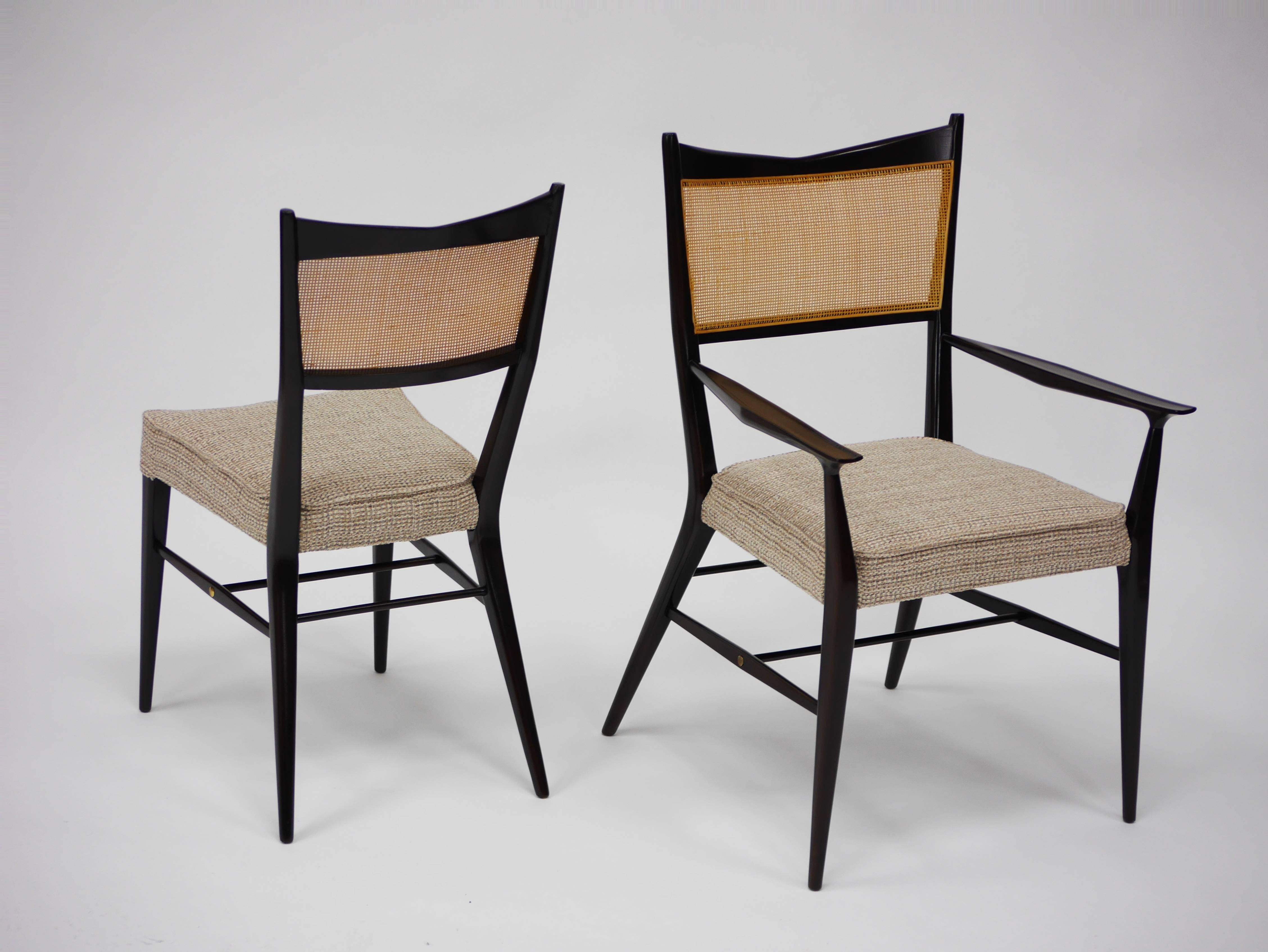 Set of ten Paul McCobb Irwin collection dining chairs with sculpted mahogany frames and caned backs. Eight side chairs, two armchairs. Refinished, re caned and newly upholstered.