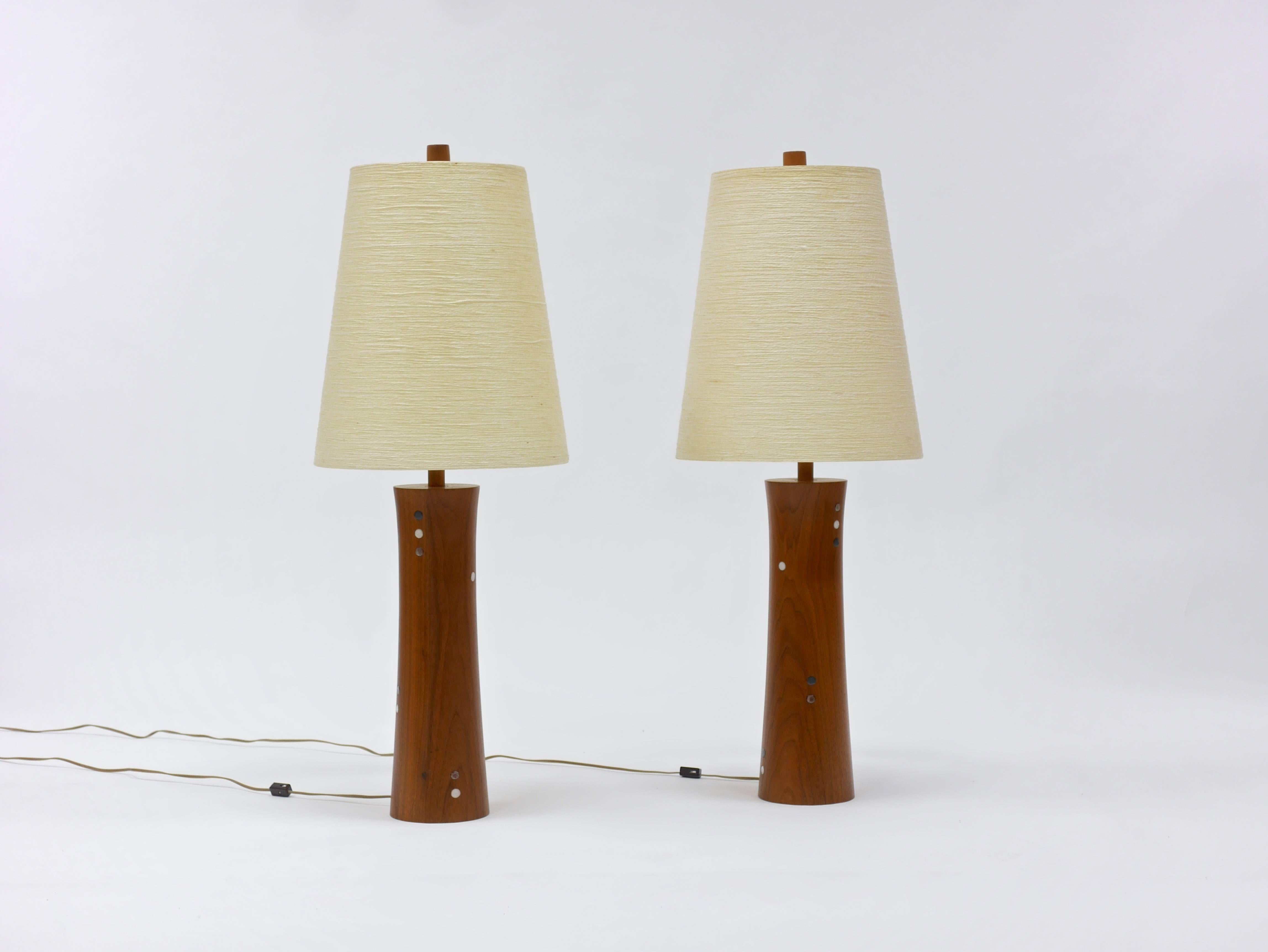 Laminated walnut, turned, hourglass forms with inlaid glazed tiles. Each with a fiberglass and jute shade by Lotte and Gunnar Bostlund. Original walnut finials. 37
