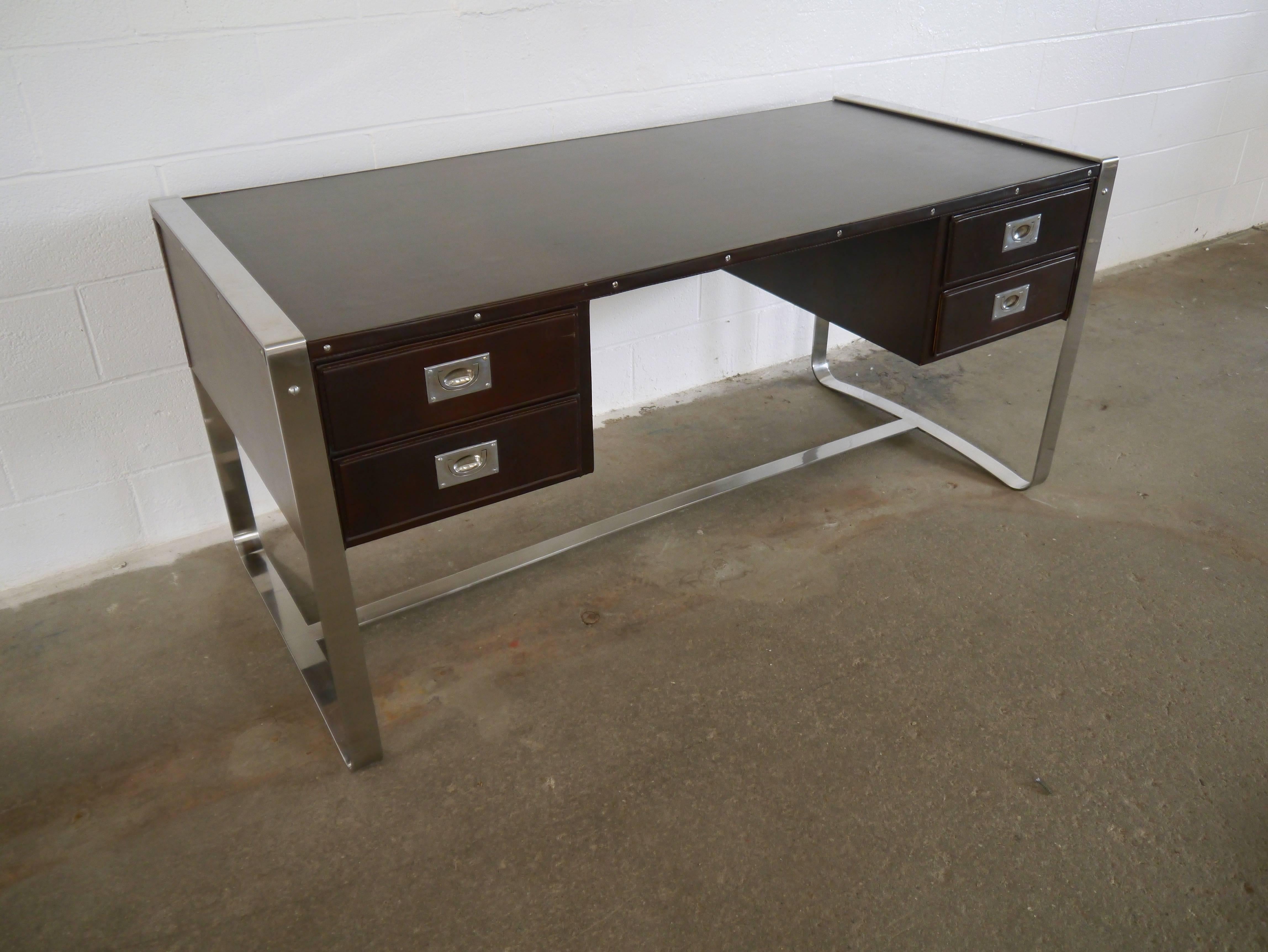 Desk by Jacques Adnet. Having a stainless steel frame, stitched leather, four drawers and handmade nickel-plated hardware.