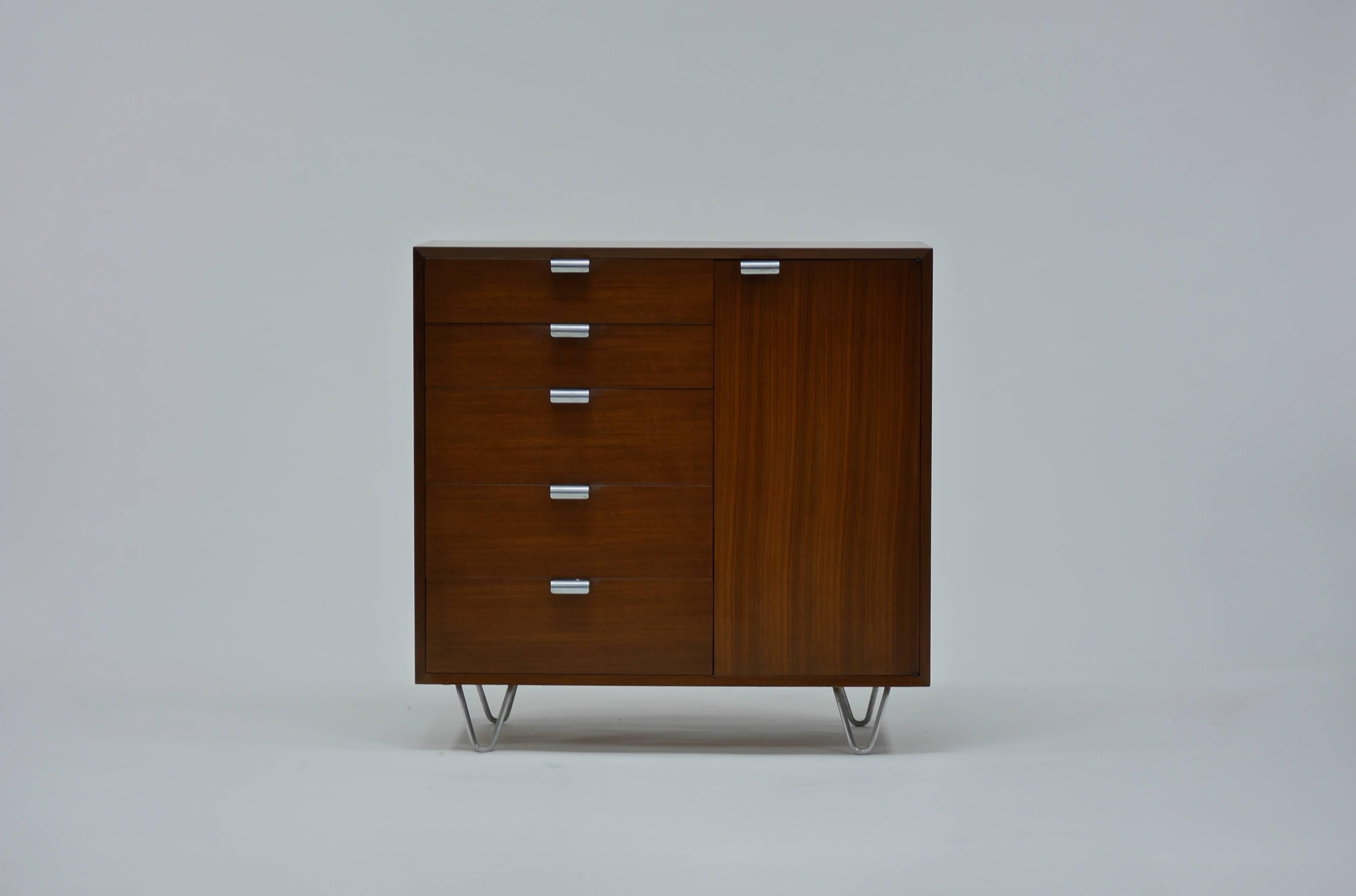 Dresser by George Nelson for Herman Miller. Model # 4606, having 5 drawers, one door concealing cabinet with two shelves.  A clean vintage example with figurative Walnut veneers.