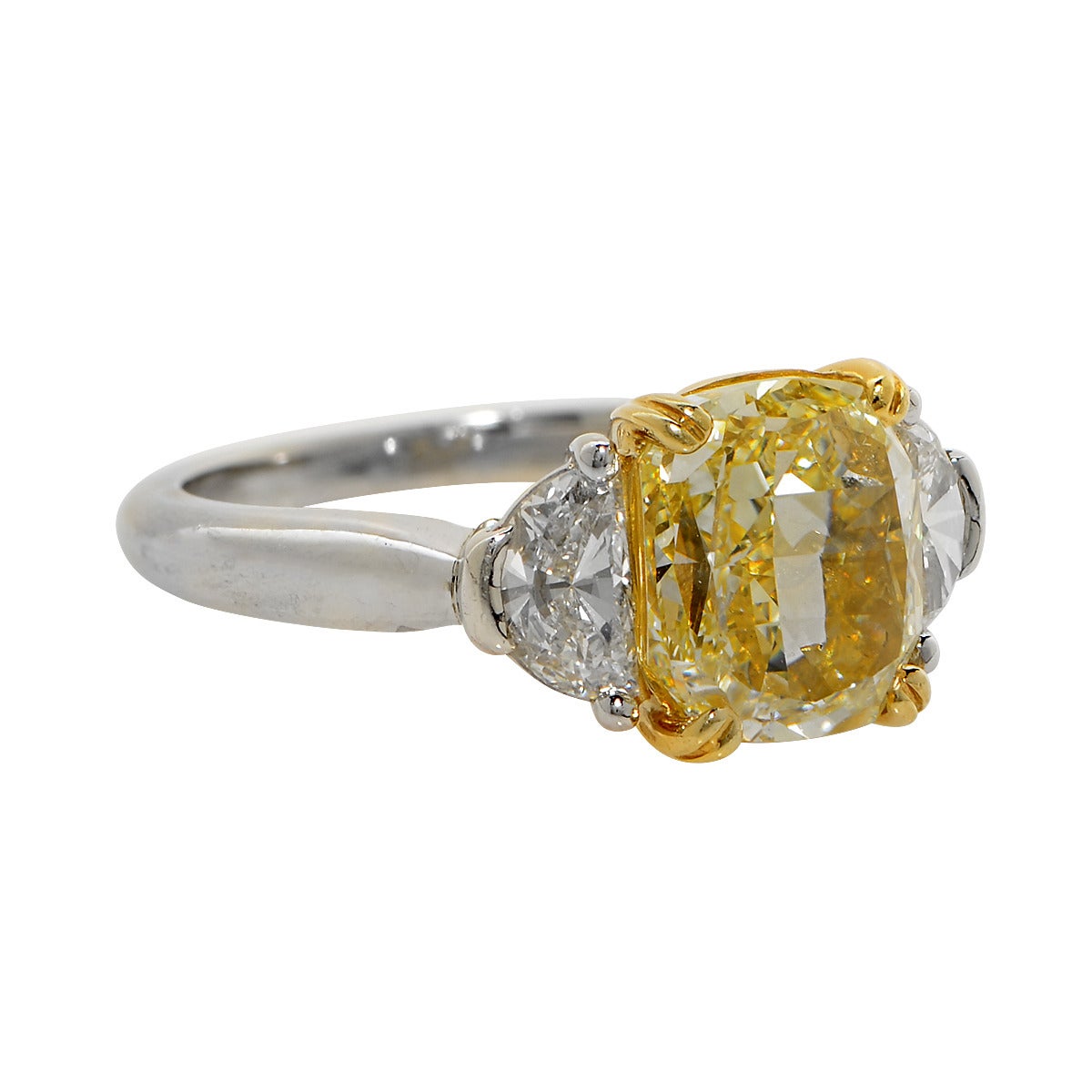 Platinum & 18k Yellow Gold Ring Set with a GIA 3.64ct Fancy Light Yellow SI1 Cushion Cut Diamond, Flanked by 2 Half Moon Cut Diamonds Weighing Approximately .75cts. Ring Size: 6.25.
