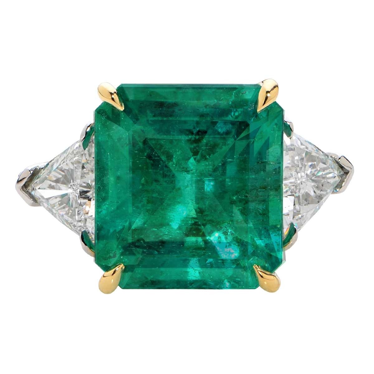 This Impressive 11.39 Carat GIA Certified Colombian Emerald is set into a Platinum Ring and is Flanked by Two Trillion Cut Diamonds with a Total Weight of 2.11cts F Color, VS Clarity.