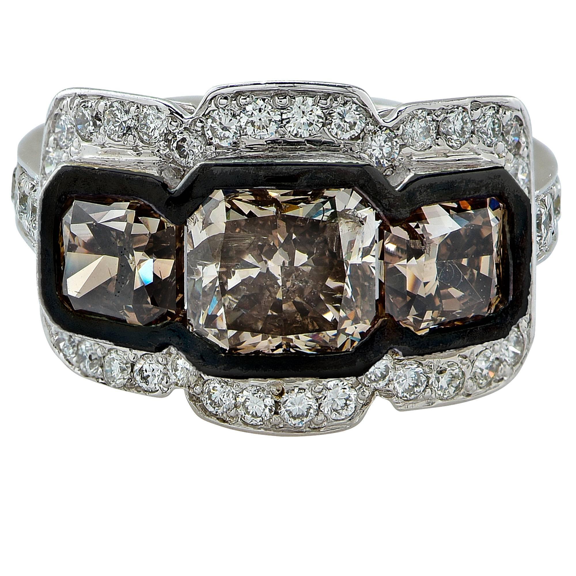 Striking ring crafted in 18 Karat white gold featuring 3 natural Brown Princess Cut diamonds weighing approximately 4.00 carats total, adorned by 48 round brilliant cut diamonds weighing approximately .74 carats total, F Color and VS Clarity. This