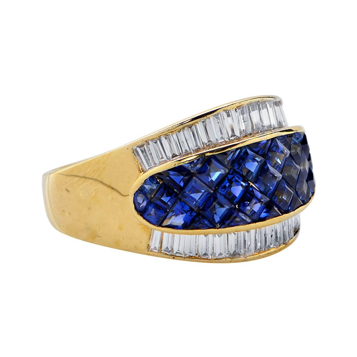 Striking band crafted in 18 karat yellow gold featuring 35 square cut sapphires weighing approximately 2.73 carats total, accented by 36 baguette cut diamonds weighing approximately 1.07 carats total, F color VS clarity. This stunning band is a size