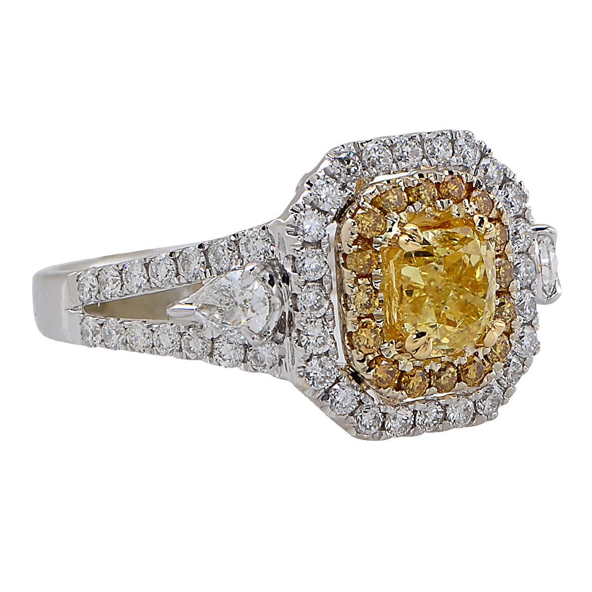 Stunning engagement ring crafted in 18 karat white and yellow gold, showcasing a GIA Certified cushion cut Natural Fancy Vivid Yellow diamond weighing 1.02 carats, accented by 70 mixed cut natural vivid yellow diamonds weighing approximately .91