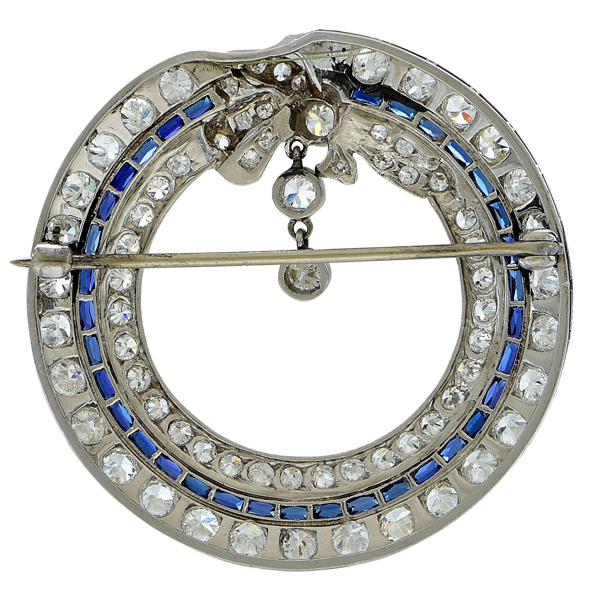 This artistically crafted platinum Art Deco brooch features 78 European cut diamonds weighing approximately 4.25cts  F-G color, VS clarity and is accented by 34 scissor cut synthetic sapphires, typical of the Art Deco period.

The brooch measures