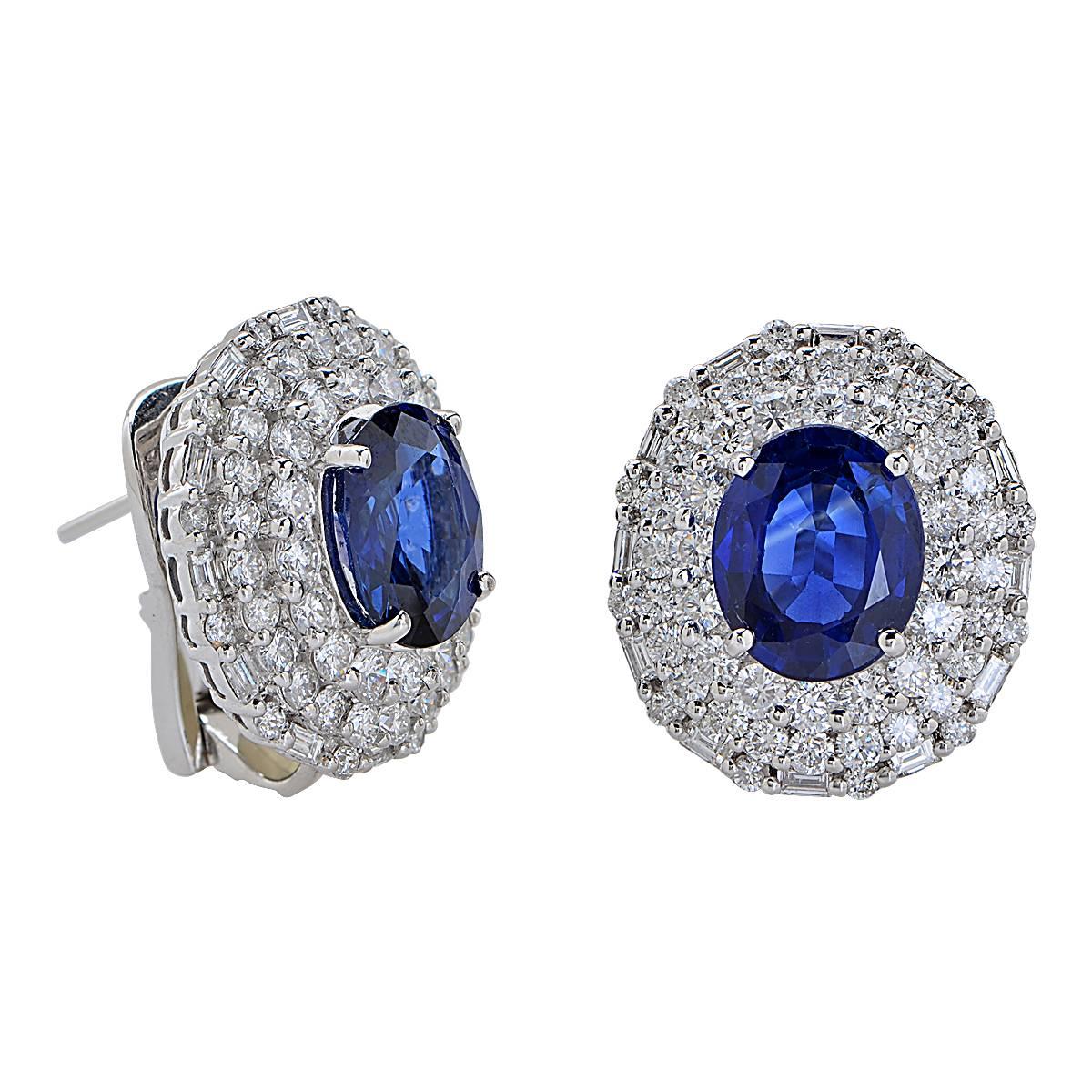 18 Karat White Gold Earrings Containing 2 Beautiful Deep Blue Oval Sapphires Weighing 6.33 Carats Surrounded by 128 Round Brilliant and Baguette Shape Diamonds Weighing 3.21 Carats, F Color, VS Clarity. These Earrings are