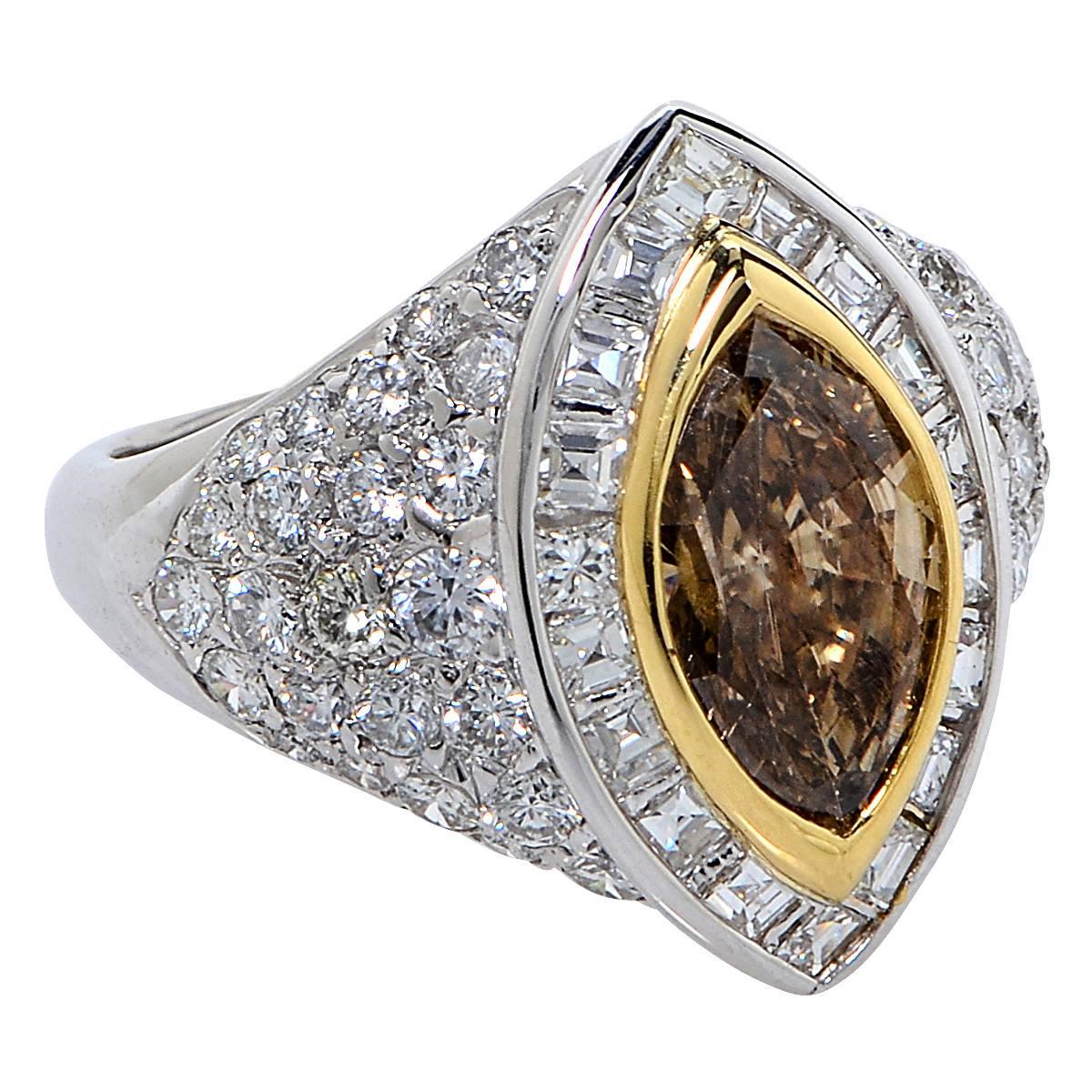 2.50 Carat Natural Fancy Brownish Yellow Diamond Set in to an 18 Karat White and Yellow Gold Ring Surrounded by 66 Mixed Cut Diamonds Weighing Approximately 3.00 Carats, F Color, VS Clarity.

Ring Size: 8.75
Weight: 9.11 grams

This Natural