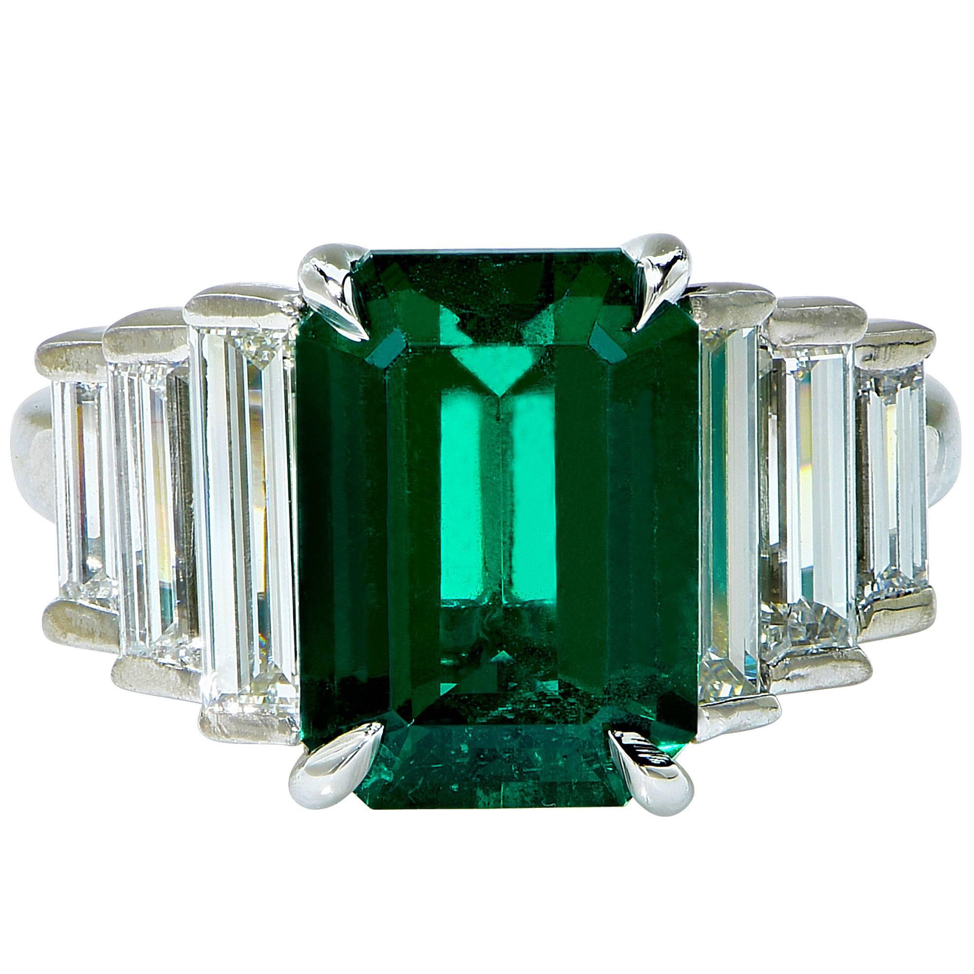 Platinum custom-made ring containing a 3.33ct gorgeous emerald cut Zambian emerald with an AGL Report stating insignificant treatment. The emerald is flanked by 6 long diamond baguettes with a total weight of approximately 2cts, F color, VS