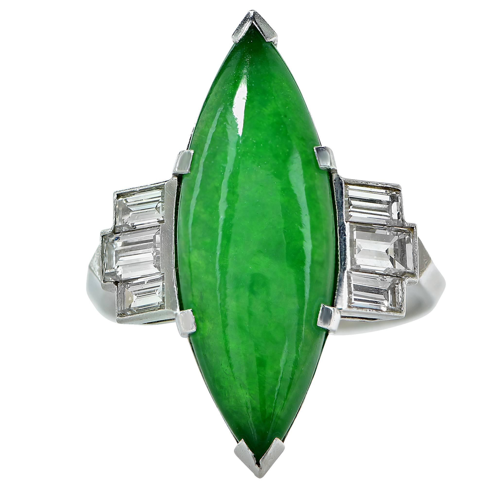 Platinring aus den 1950er Jahren mit einem GIA-geprüften natürlichen Jade-Cabochon mit einem Gewicht von ca. 5,50cts, akzentuiert durch 6 Diamanten im Baguetteschliff mit einem Gesamtgewicht von ca. 1,10cts, Farbe F, Reinheit VS.

Der Ring hat die