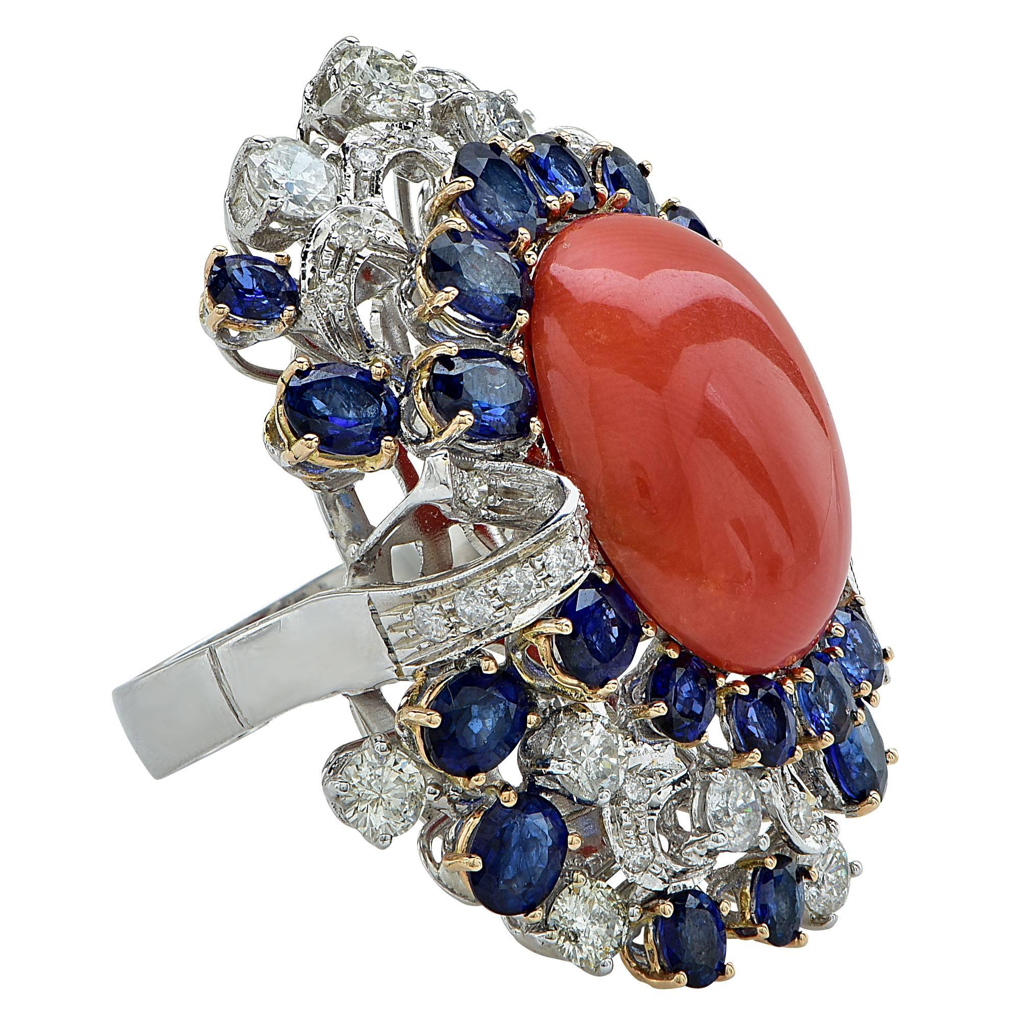 14k white gold ring featuring a coral cabochon accented by approximately 5.00cts of sapphires and 2.20cts of round brilliant cut diamonds, G-I color, VS-SI clarity.

Ring size: 6 (can be sized up or down free of charge)
Metal weight: 22.08