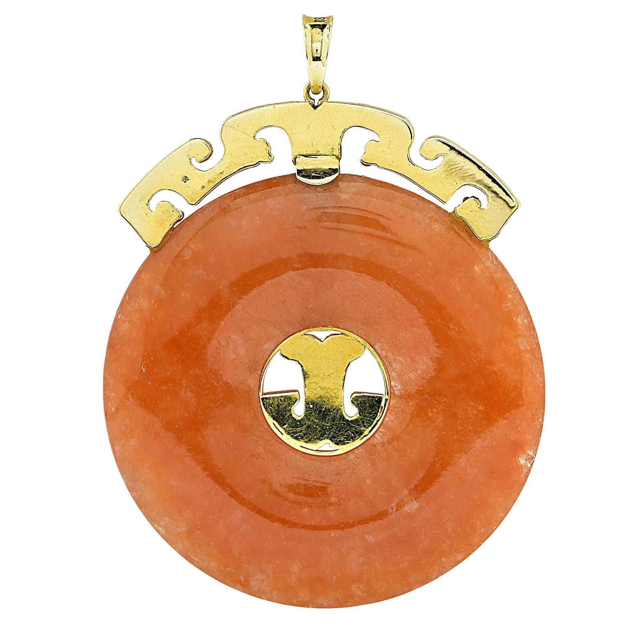 Most people think of green when they think of jade. Jadedite is white in its pure form and appears in a wide range of colors. This intriguing orange jade pendant contains a large circular carving accented by yellow gold. Orange jade is said to bring