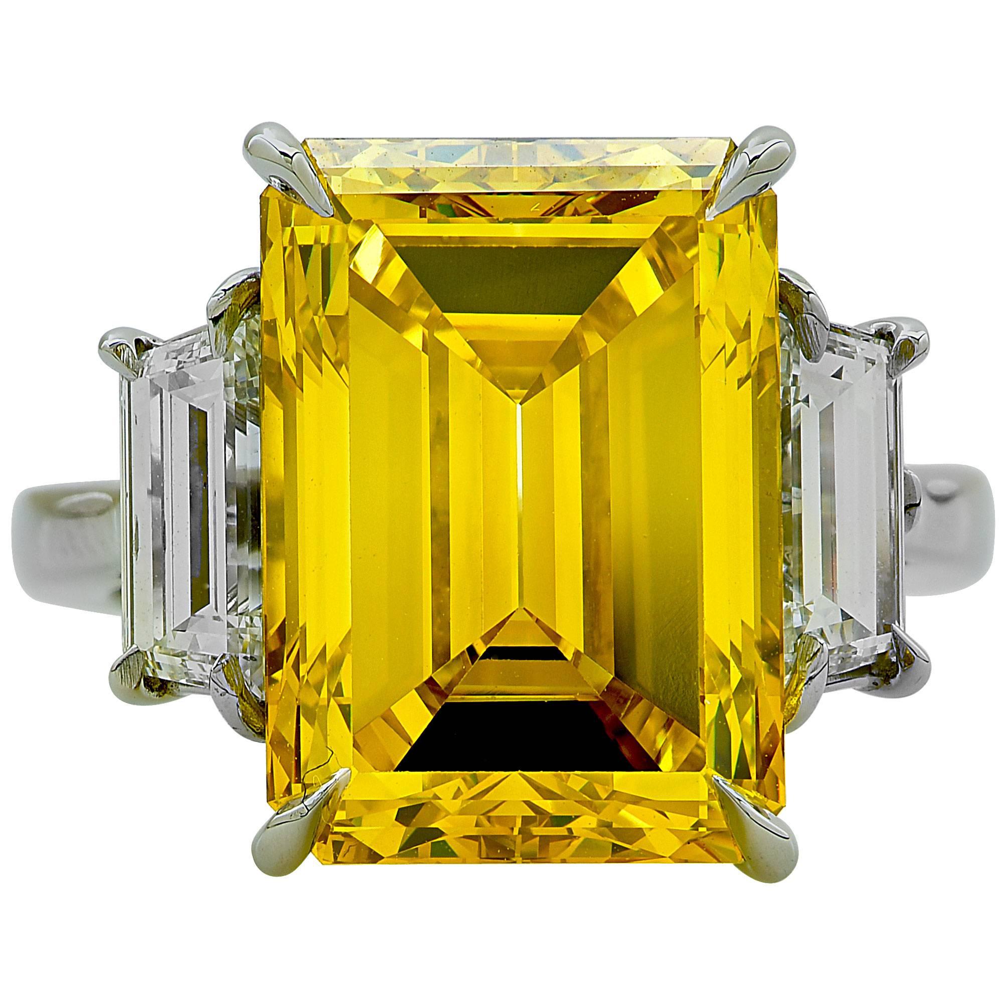Platinum hand-made ring featuring a GIA graded 10.61ct fancy deep yellow, VS2 clarity, irradiated color emerald cut diamond flanked by 2 trapezoid cut diamonds weighing 1.40cts total, F color, VS clarity.

Ring size: 6 (can be sized up or