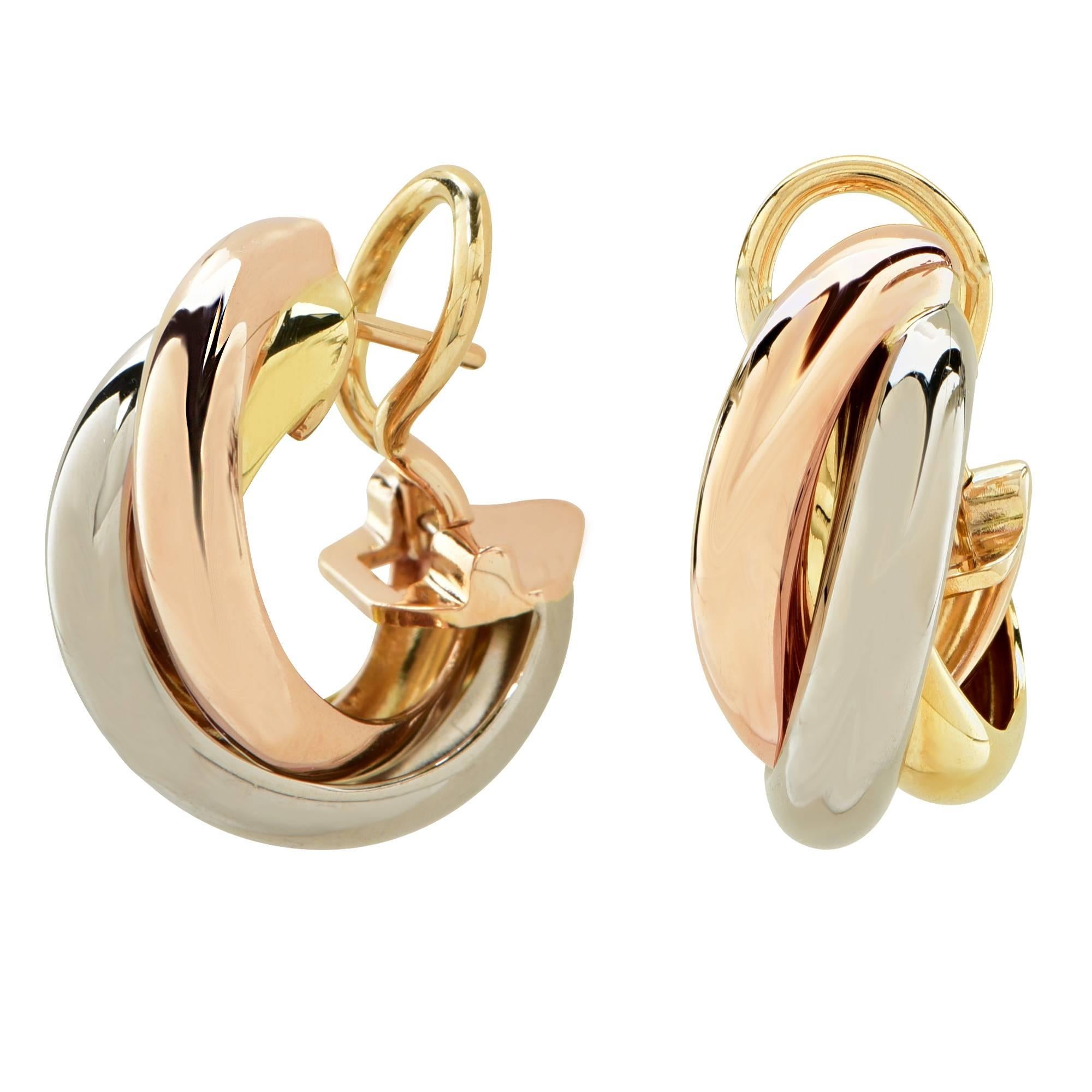 Cartier Trinity hoop earrings, featuring three bands, three colors, pink, yellow and white gold. Cartier created this design in 1924 and the style quickly earned iconic status. The tri-color gold represents, pink for love, yellow for fidelity and