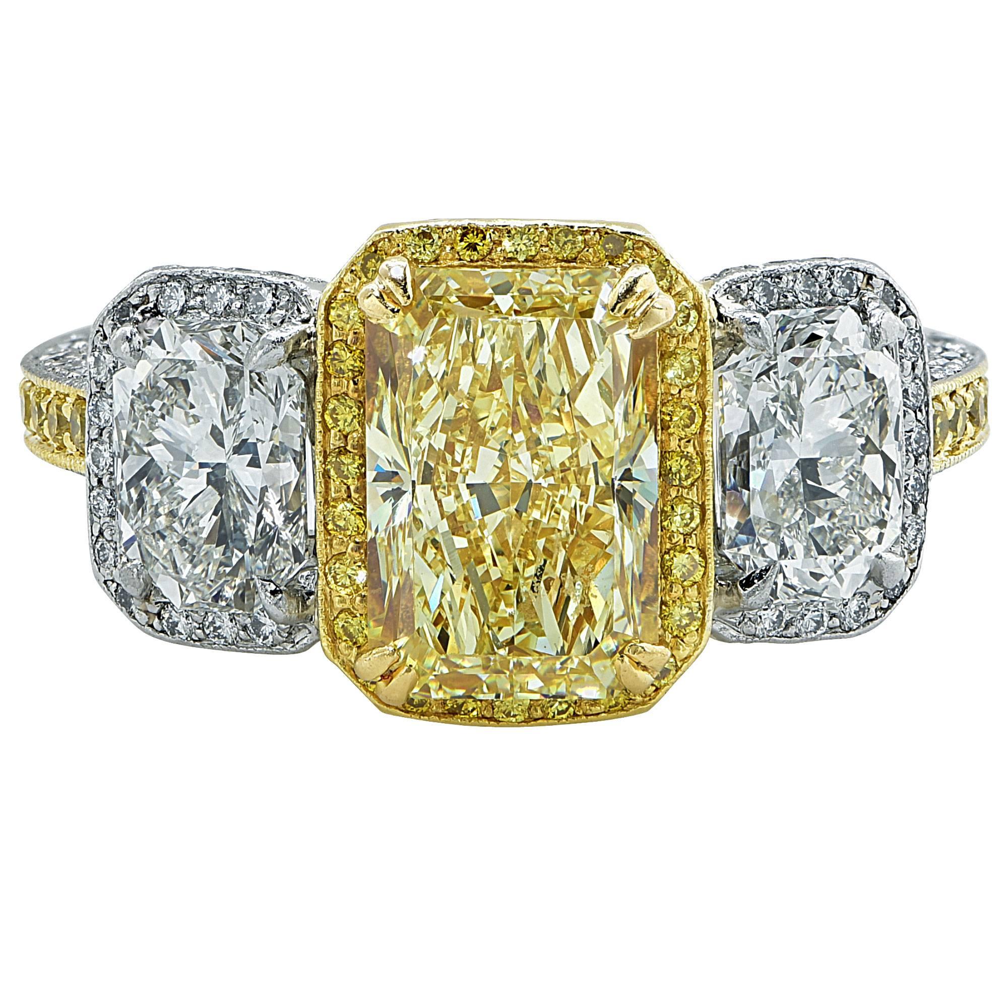 Platinum and 18k yellow gold ring featuring a 3.05ct radiant cut diamond natural fancy yellow VS1 clarity GIA, flanked by 2 radiant cut diamonds weighing approximately 2.70cts total E-F color VS1-2 clarity, accented by 182 round brilliant cut fancy