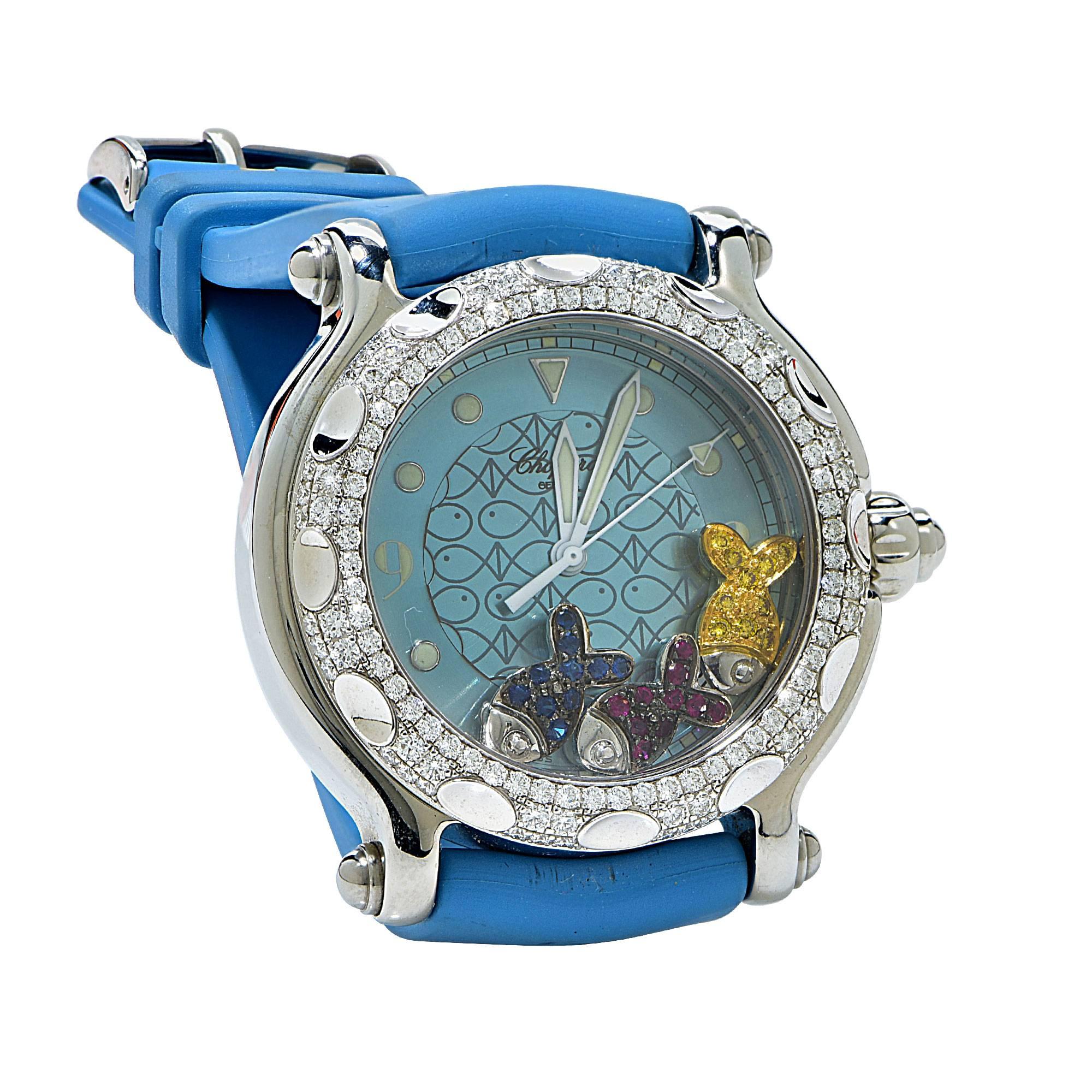 Chopard Happy Sport 28/8914. White gold - Stainless steel. The bezel features 120 round brilliant cut diamonds weighing 1.37ct F color and VS clarity. The floating fish feature 10 Rubies .15cts, 10 yellow sapphires .15cts and 10 blue sapphires