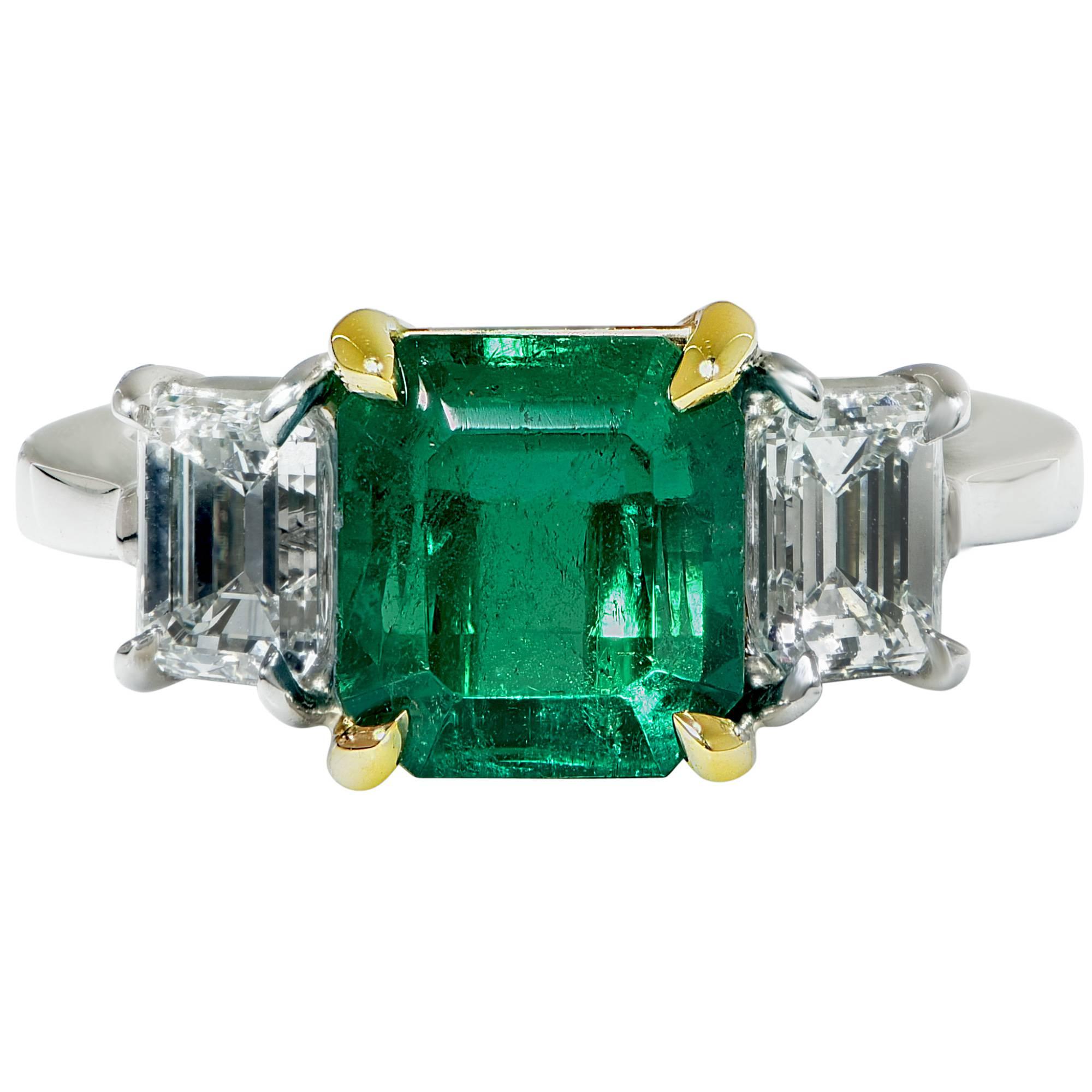 This gorgeous platinum and 18k yellow gold three stone ring features an AGL graded 2.66ct Colombian emerald and is accented by two emerald cut diamonds weighing 1.23ct total, G-H color, VS-SI clarity.

The ring size is currently 6 but can be sized
