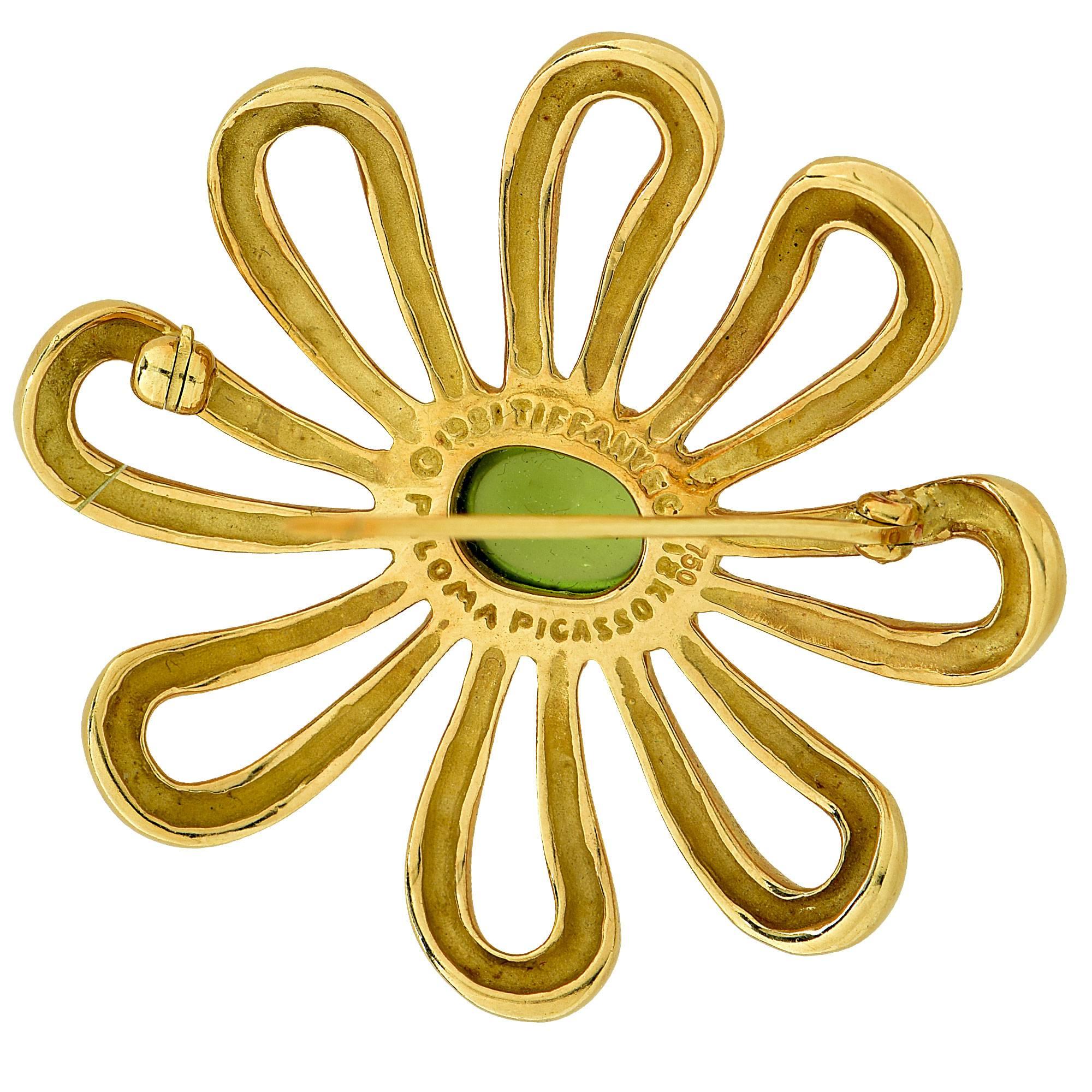 18k yellow gold Tiffany & Co. Paloma Picasso brooch featuring a peridot cabochon weighing approximately 3cts.

The brooch measures 1.54 inches in height by 1.65 inches in width by .36 inch in depth.
It is stamped and tested as 18k gold.
The