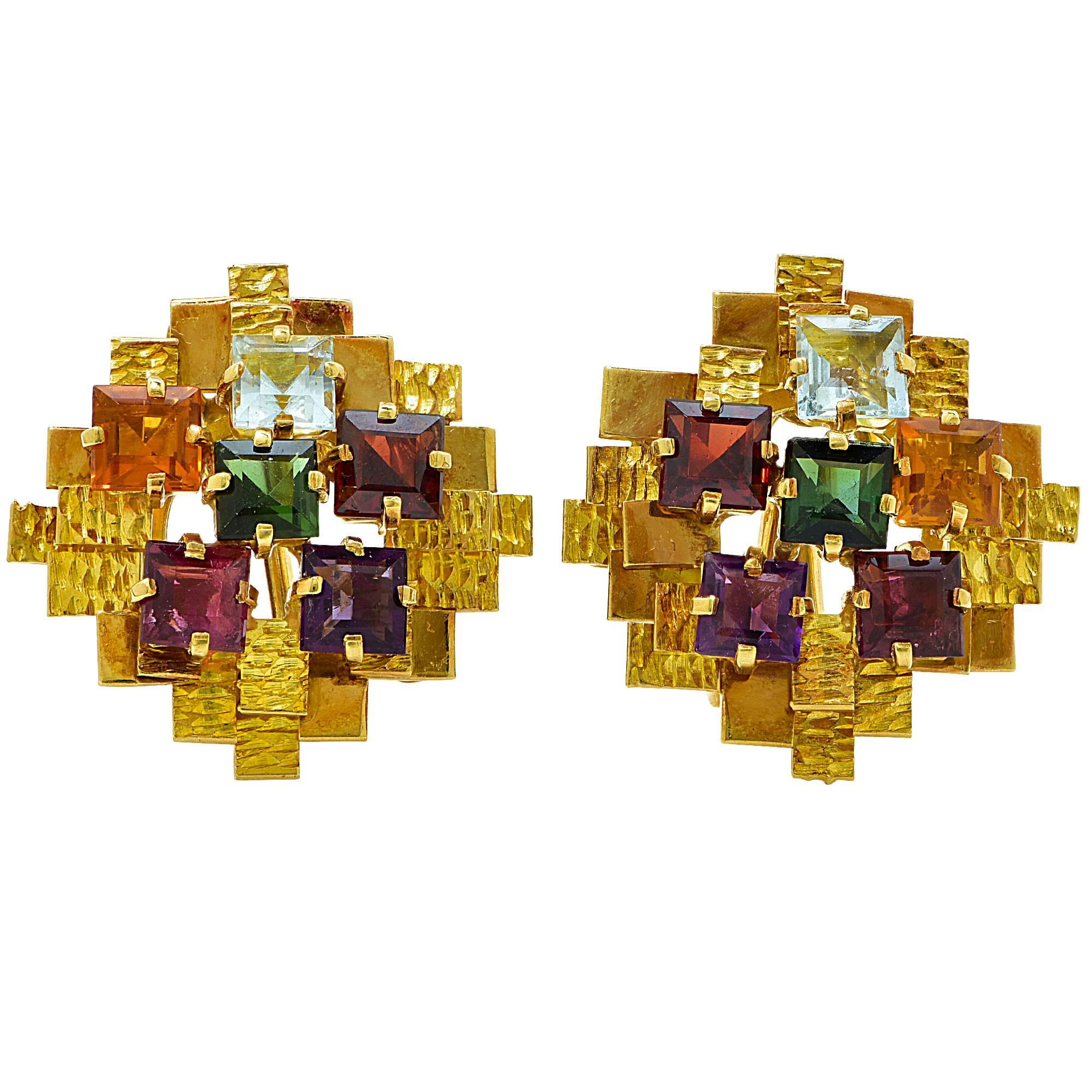 18k yellow gold dimensional earrings and brooch set containing a mixed variety of vibrant Tourmaline and quartz square step cuts.

The earrings measure 25mm by 25mm at the widest points. The brooch measures 39mm by 39mm at the widest point.
The