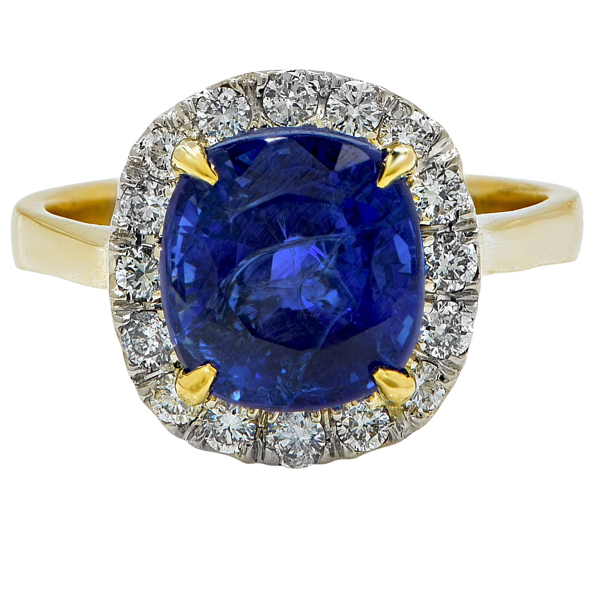 AGL graded 4.97ct vibrant heated blue sapphire from Madagascar set in to an 18k yellow gold ring and surrounded by 16 round brilliant cut diamonds G-H color and SI1 clarity.

The ring is a size 6 and can be sized up or down.
It is stamped and tested