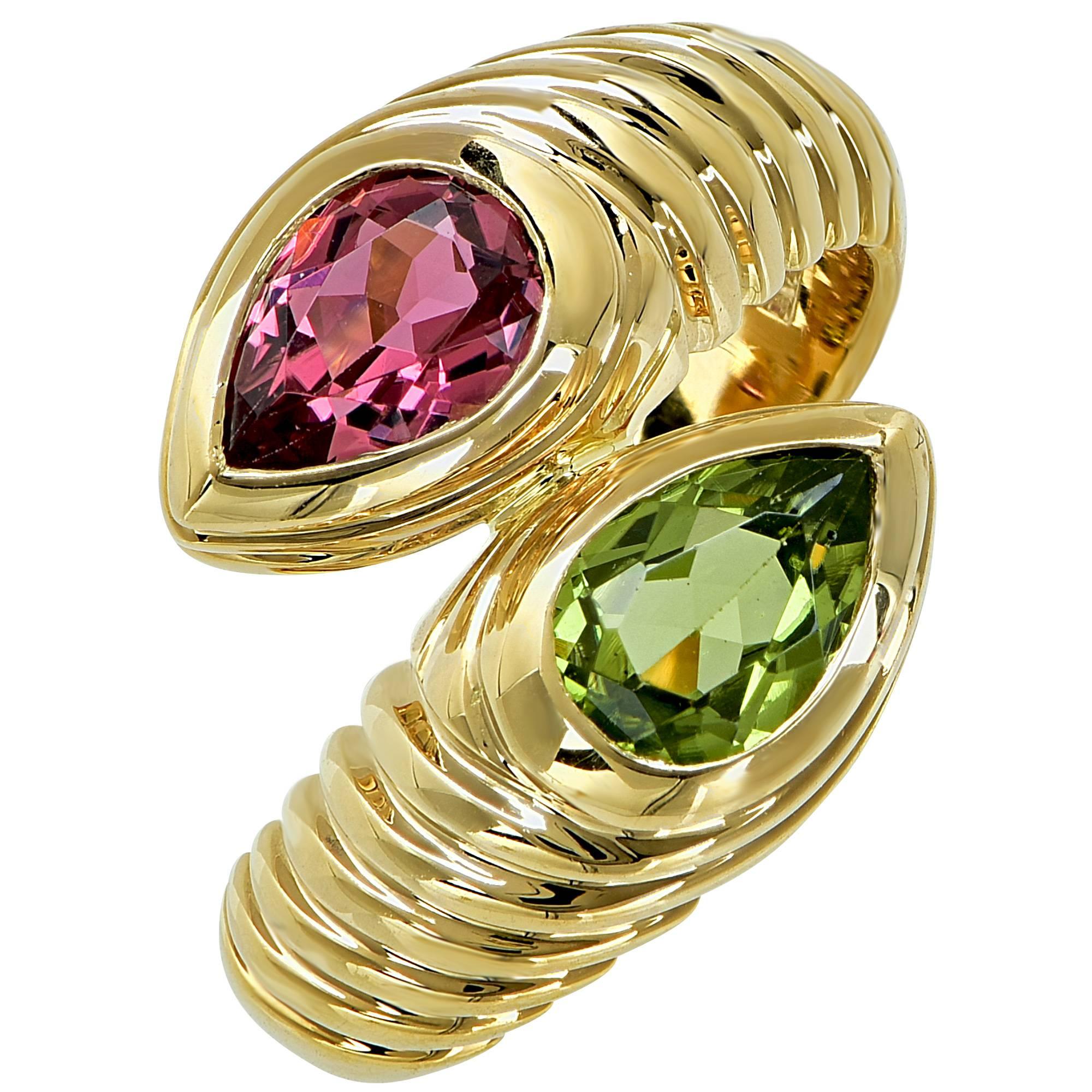 Authentic Bulgari Doppio 18k gold ring featuring a pear shaped pink tourmaline and a pear shaped peridot.

The ring is a size 5.5 and can be sized.
It is stamped and tested as 18k gold.
The metal weight is 10.57 grams.

This Bulgari ring is