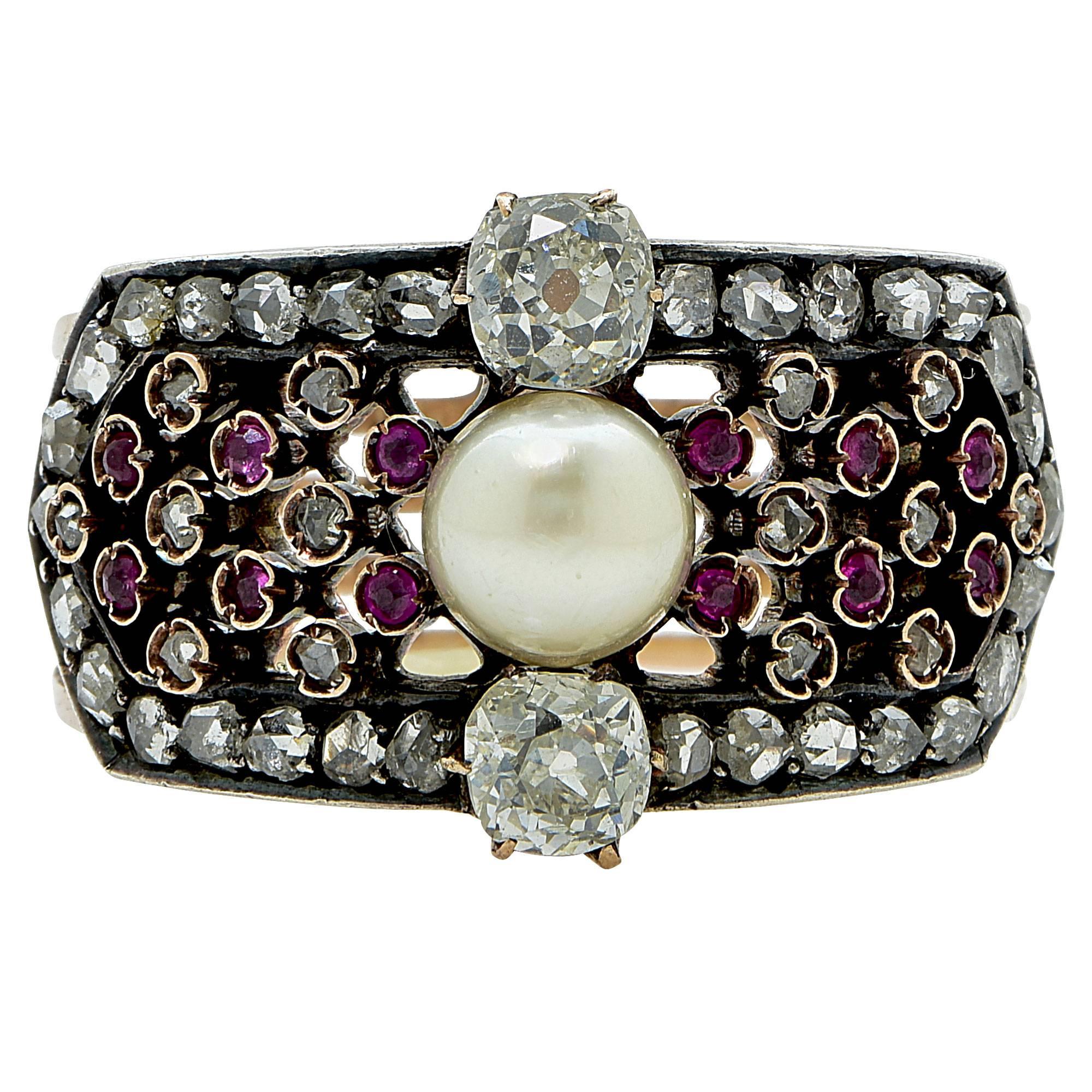 Silver over gold Victorian ring featuring a 6mm natural pearl flanked by 2 miner cut diamonds weighing approximately .70cts total, G-H color VS-SI clarity. Accented by 44 rose cut and miner diamonds weighing approximately .60cts total and 12 rubies