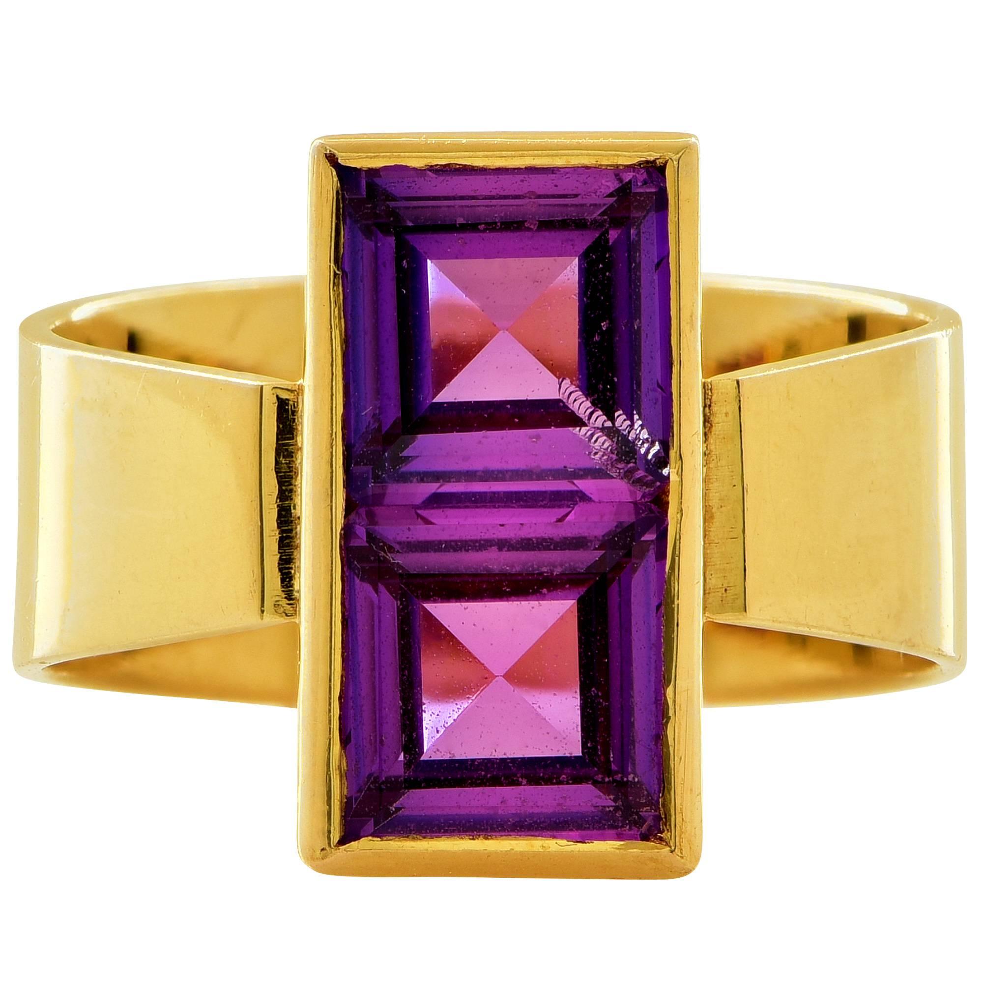 18k yellow gold ring featuring 2 square cut synthetic purple sapphires weighing approximately 4cts total.

The ring is a size 5.5 and can be sized up or down.
It is stamped and tested as 18k gold.
The metal weight is 7.93 grams.

This purple